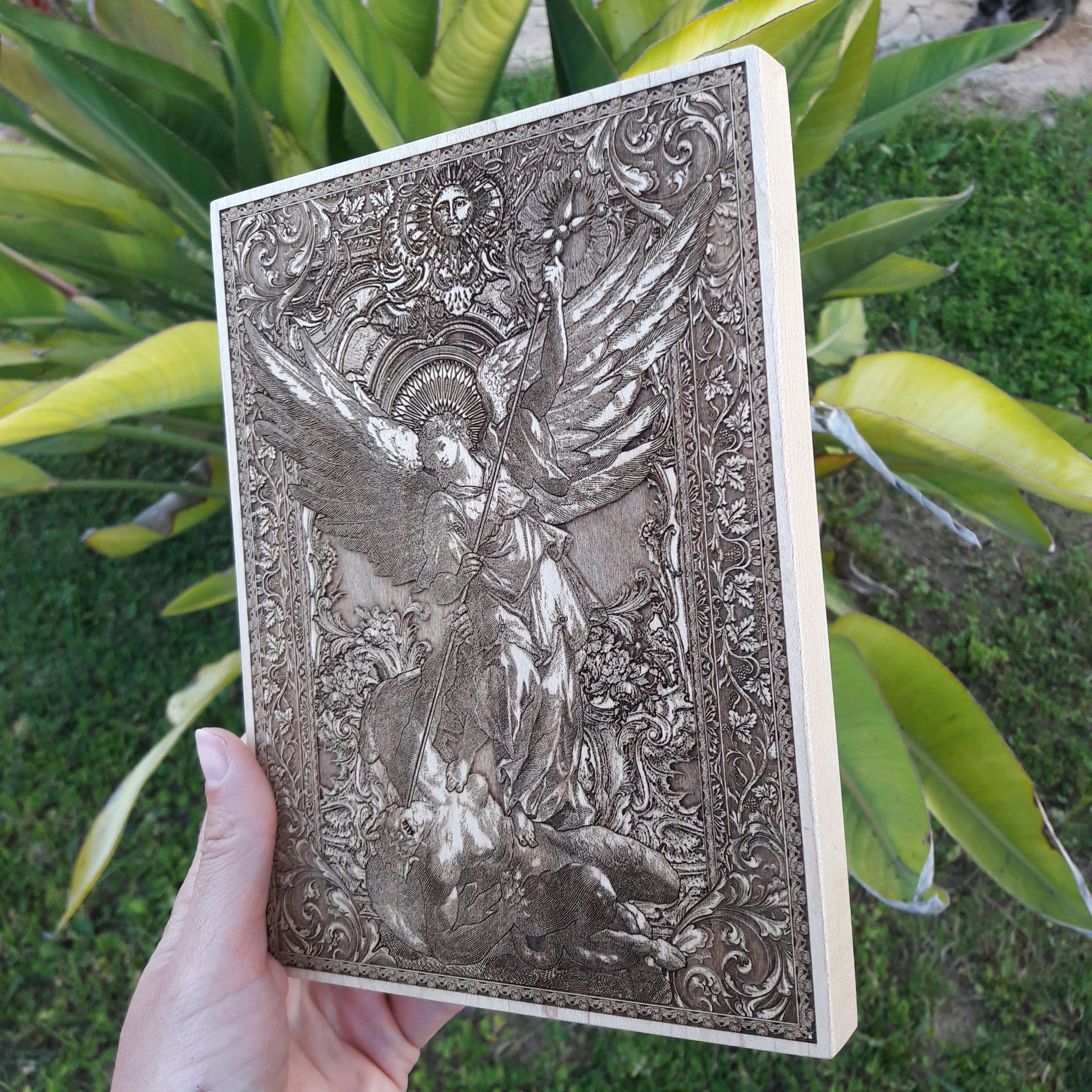 Saint Michael defeating the devil, engraved on wood – a powerful Christian art piece.