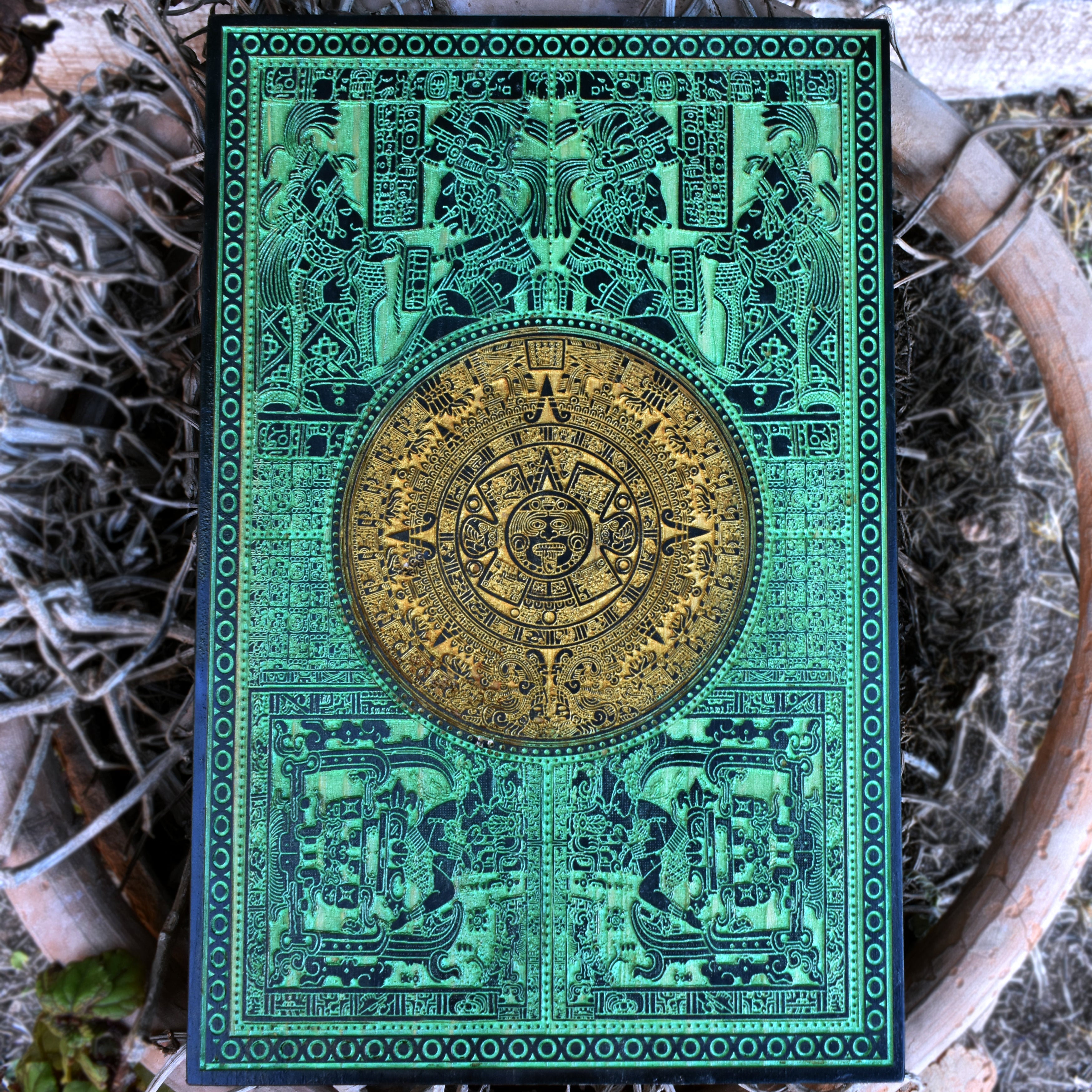 Green engraved Aztec calendar wood wall art with detailed Mayan sun stone design.