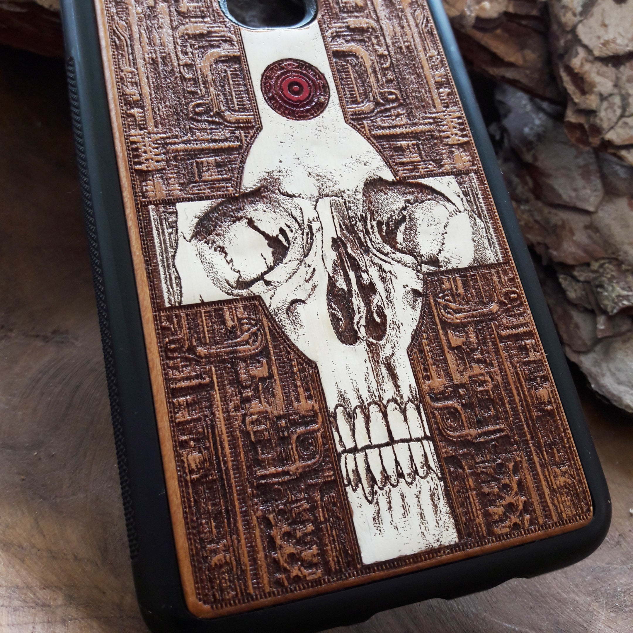 Laser-engraved wooden phone case featuring a gothic skull and cross design, compatible with iPhone 16, iPhone 15, Galaxy S25, and more