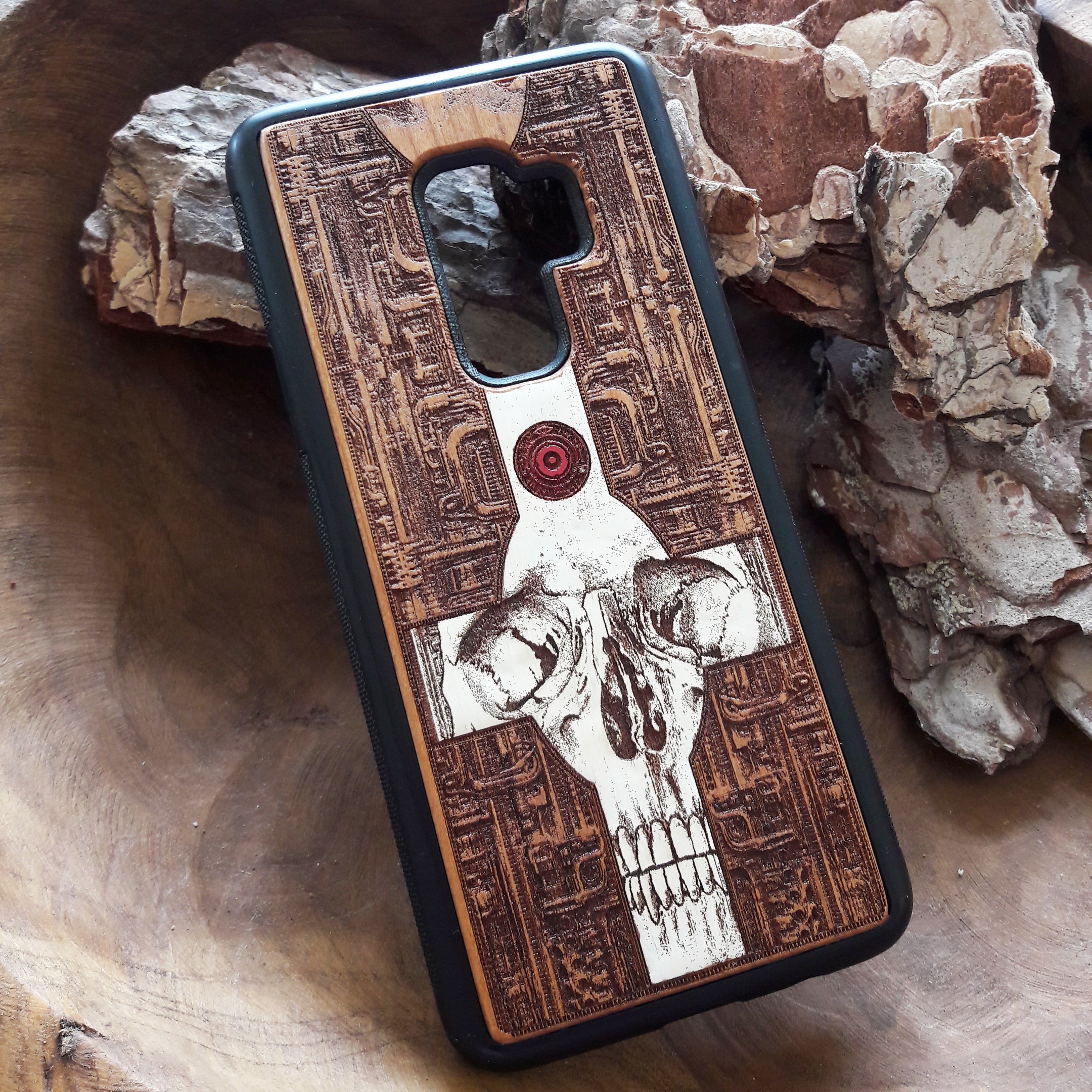Laser-engraved wooden phone case featuring a gothic skull and cross design, compatible with iPhone 16, iPhone 15, Galaxy S25, and more