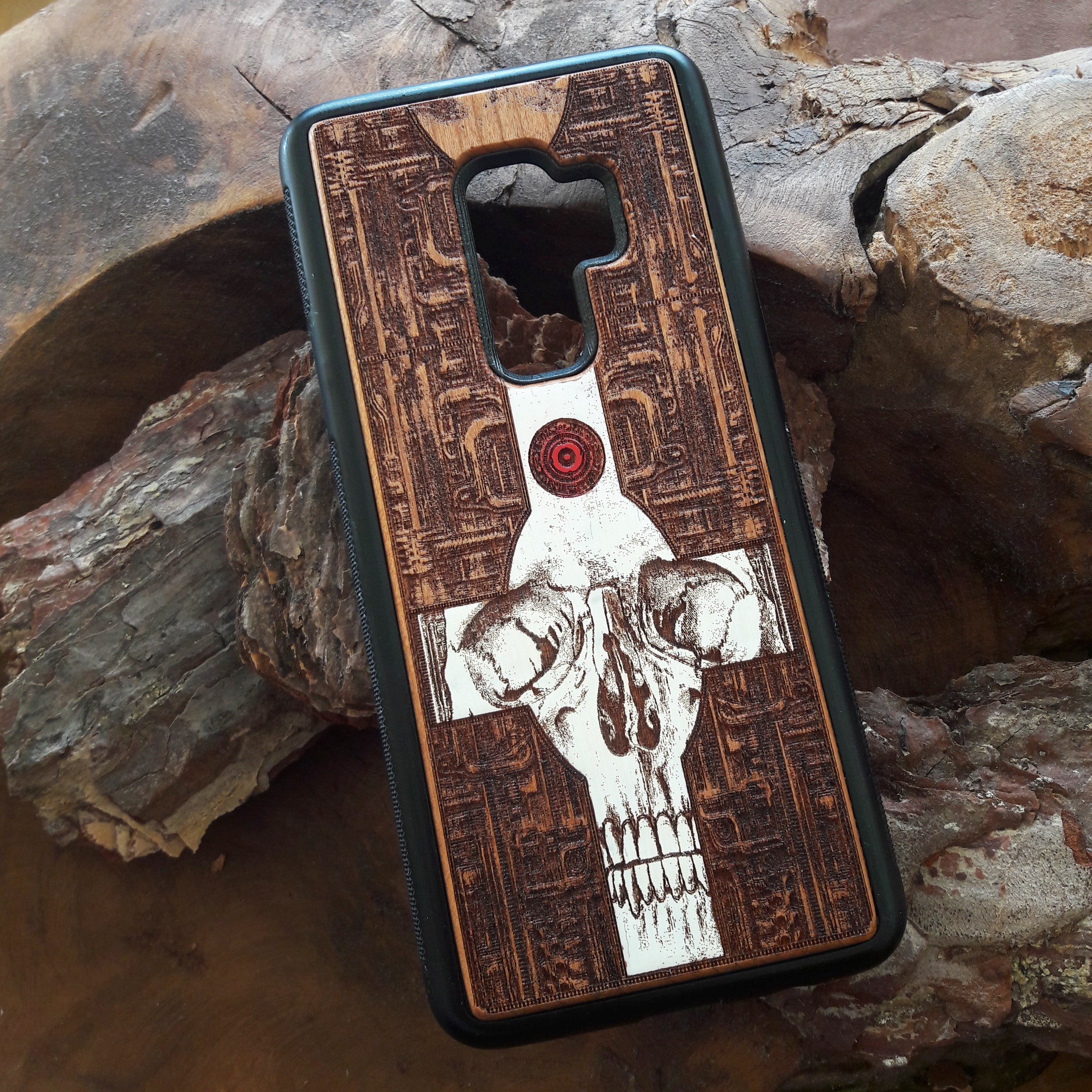 Laser-engraved wooden phone case featuring a gothic skull and cross design, compatible with iPhone 16, iPhone 15, Galaxy S25, and more