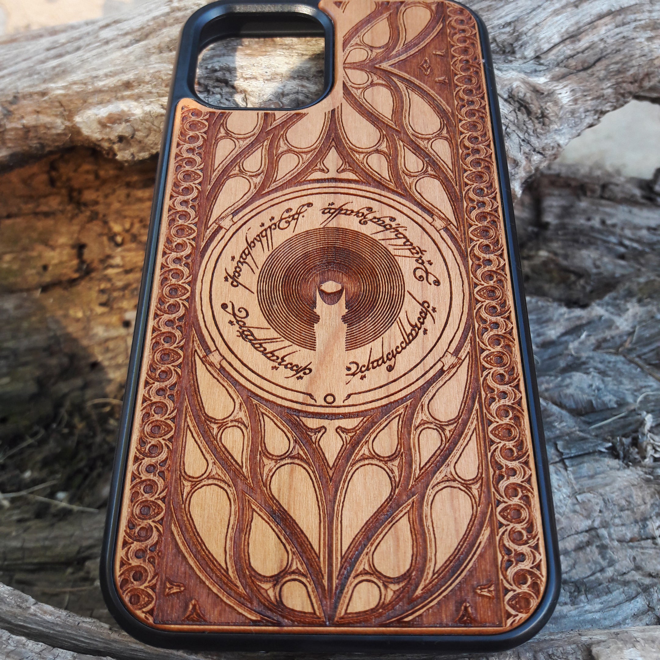 Wooden phone case featuring a Gothic Lord of the Rings-inspired design, with intricate laser-engraved patterns. The design includes dark, medieval-style elements with Elvish script, capturing the essence of Middle-Earth's dark aesthetic. Compatible with iPhone , 15, 14, 13, 12, 11 Pro Max Mini, and Samsung Galaxy S, S24, S23, S22, S21, S20 Ultra, Plus, and Note 20. A unique and protective accessory for Tolkien fans with a taste for Gothic style.