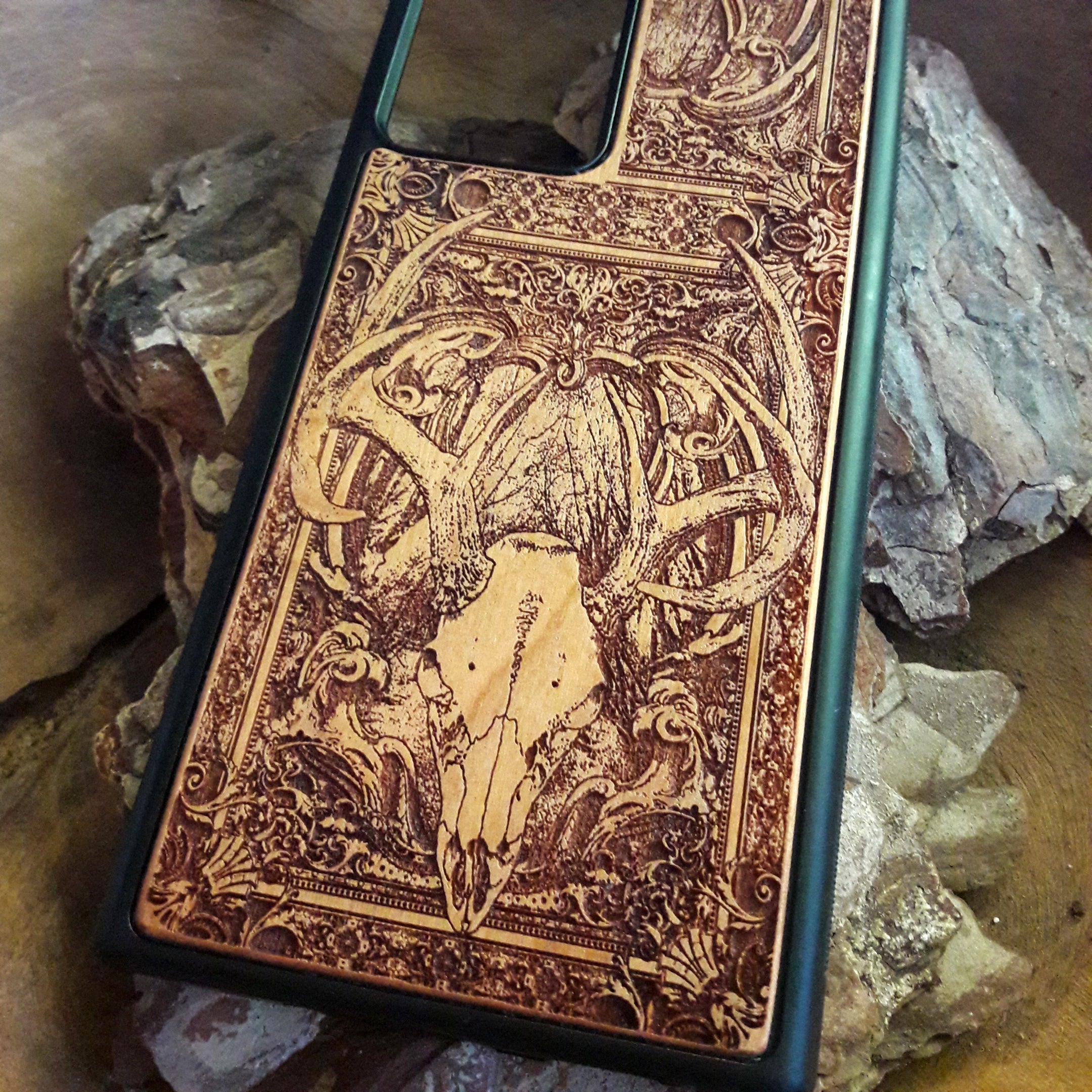 Wooden phone case with an intricately engraved antler skull design, blending nature-inspired and gothic elements. Suitable for iPhone , iPhone 15, iPhone 14, iPhone 13, Samsung Galaxy S, S24, S23, S22, and more. A perfect match for fans of rustic style, hunting, and unique artistic designs.