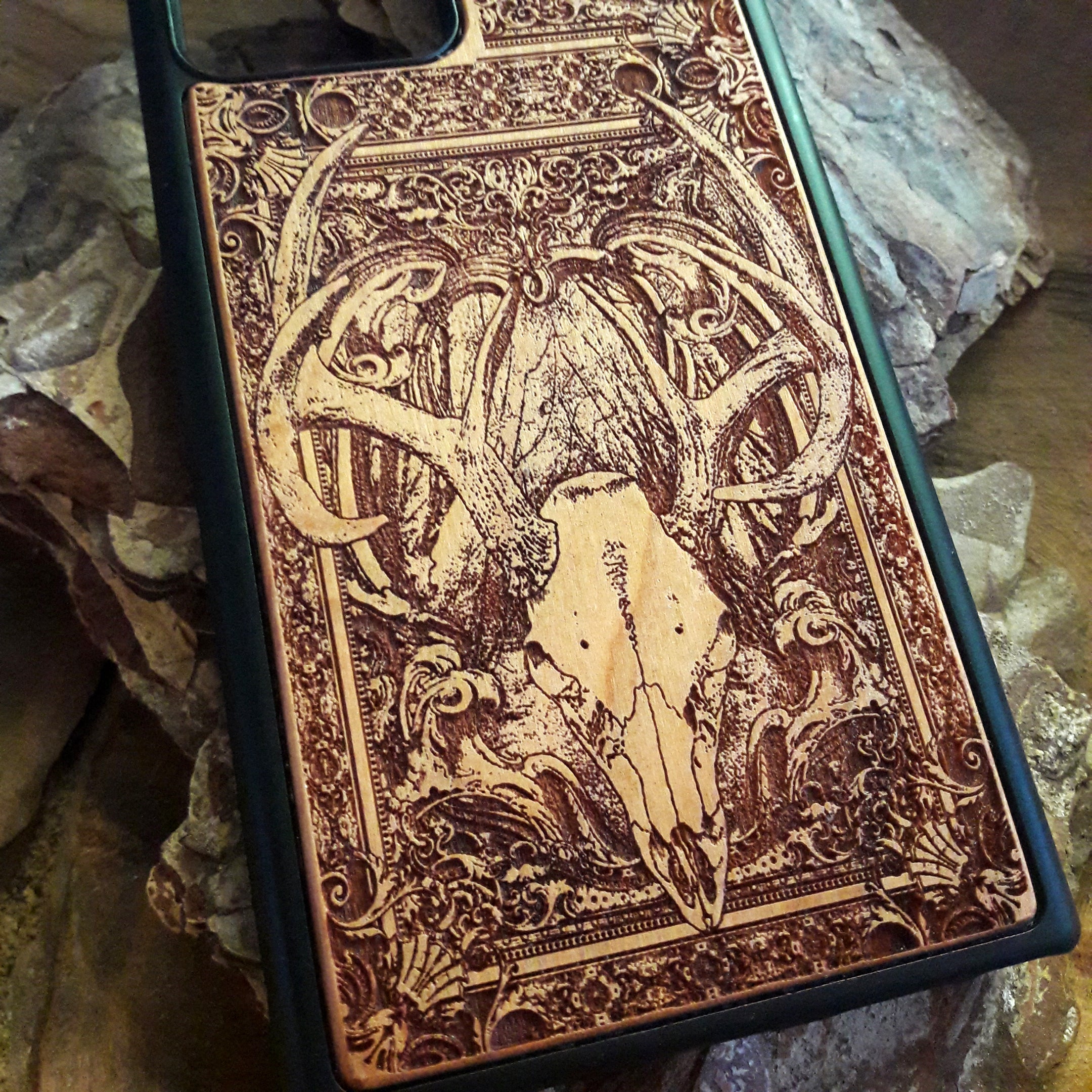 Wooden phone case with an intricately engraved antler skull design, blending nature-inspired and gothic elements. Suitable for iPhone , iPhone 15, iPhone 14, iPhone 13, Samsung Galaxy S, S24, S23, S22, and more. A perfect match for fans of rustic style, hunting, and unique artistic designs.