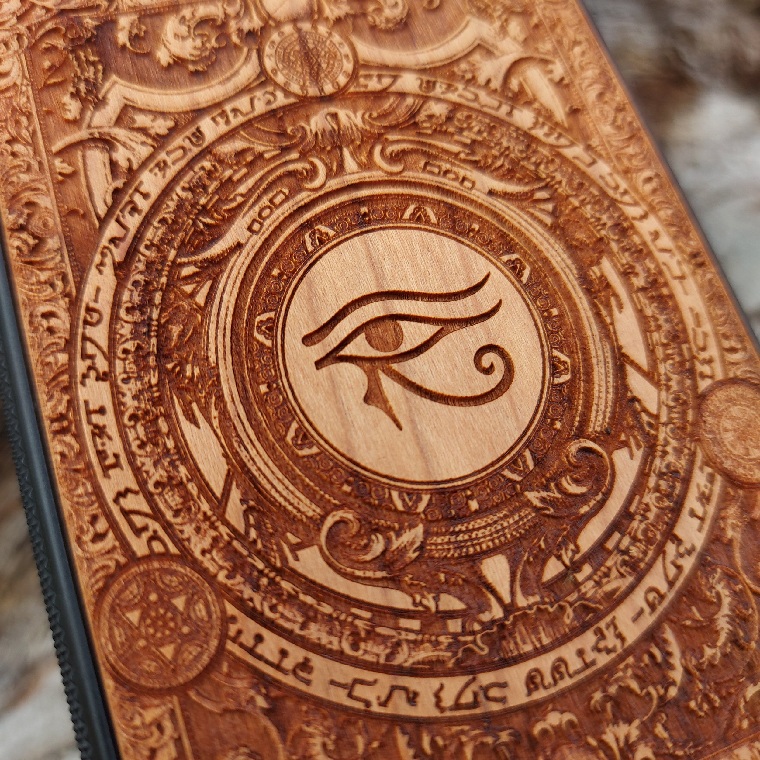 Handcrafted wooden phone case featuring the Eye of Ra symbol intricately engraved with ancient Egyptian-inspired detailing. Designed for iPhone , 15, 14, 13, 12, 11, Pro Max, Mini, and Samsung Galaxy S, S24, S23, S22, S21, S20 Ultra, Plus, Note 20 models. A unique fusion of art and protection for those who admire Egyptian mythology and premium craftsmanship.