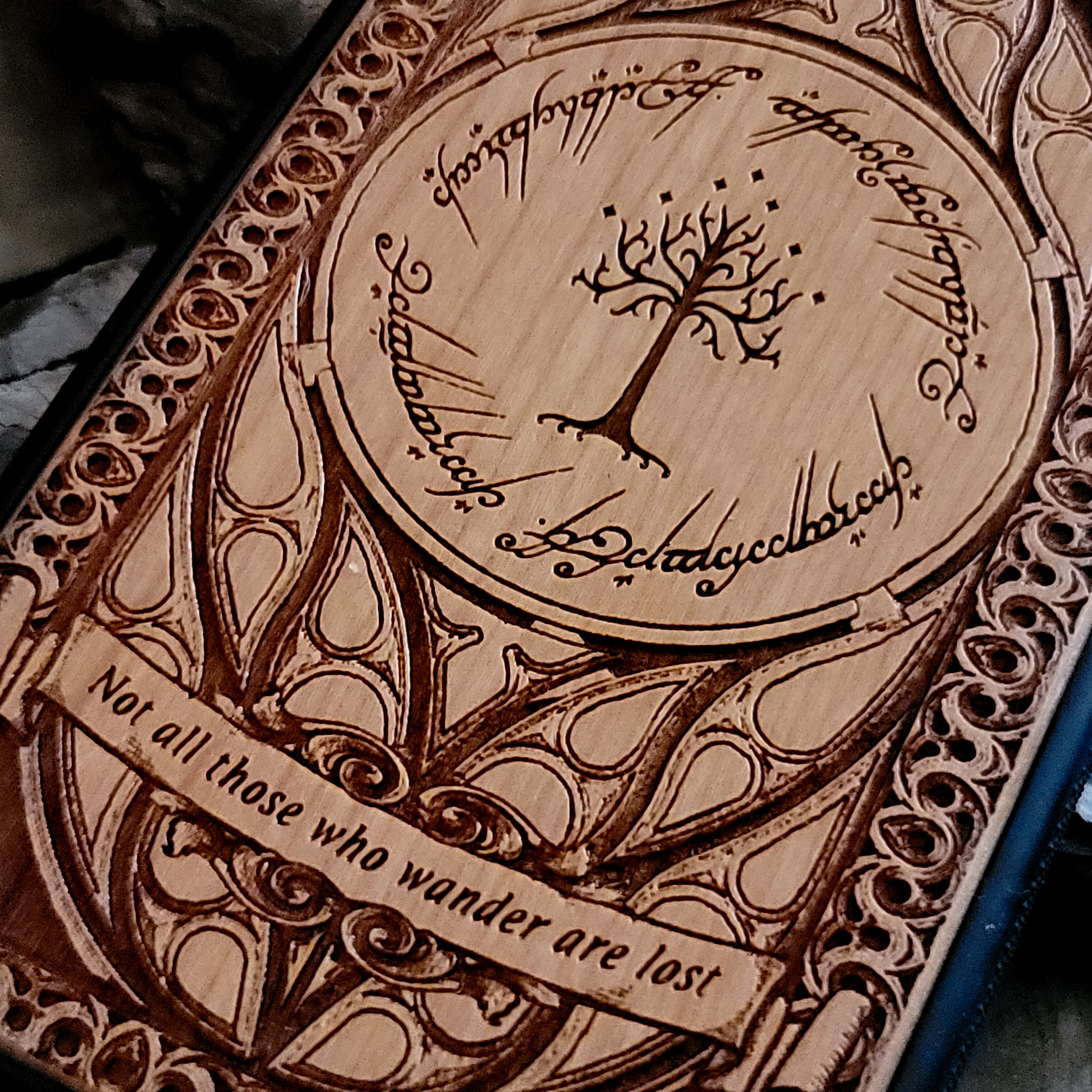 Lord of the Rings wood phone case featuring the White Tree of Gondor, Elvish script, and the iconic quote 'Not all those who wander are lost.' Laser-engraved with intricate detailing, this durable and elegant case is compatible with iPhone , 15, 14, 13, 12, 11, Pro Max, Mini, and Samsung Galaxy S, S24, S23, S22, S21, S20 Ultra, Plus, Note 20. A unique protective accessory for Tolkien fans.