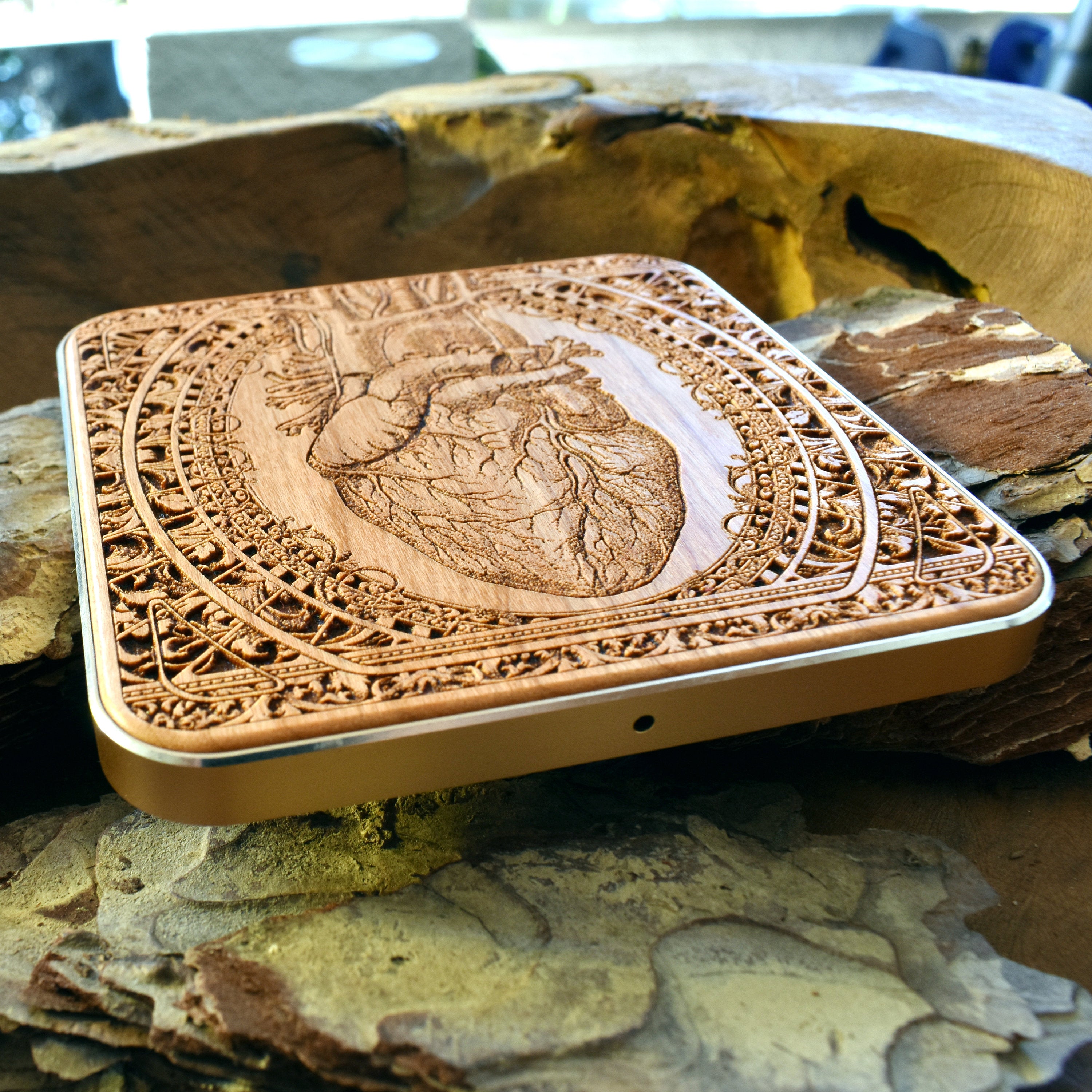 Detail view of engraved wooden wireless charger with Qi technology for iPhone 16.