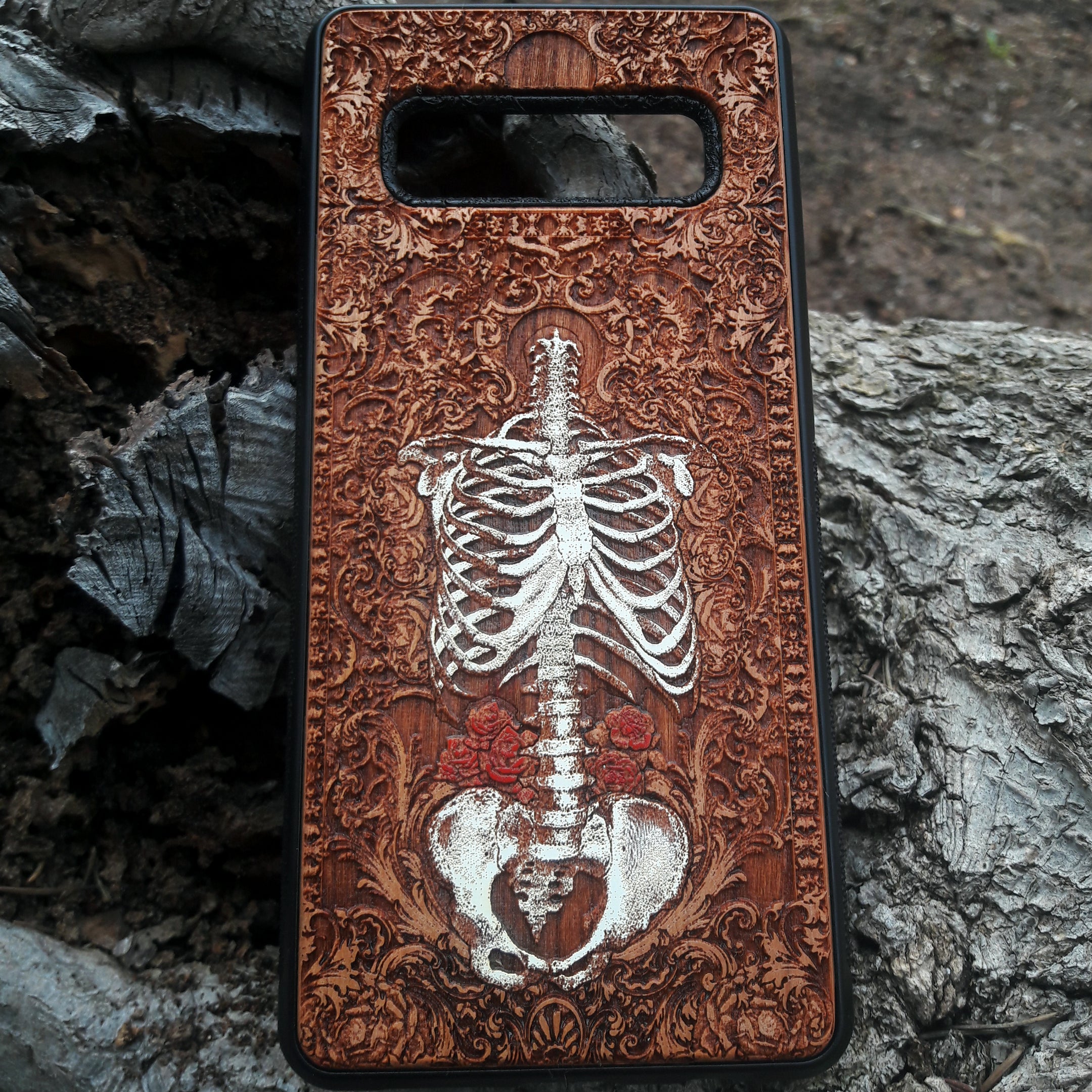 Laser-engraved anatomical human skeleton design on a wooden phone case, compatible with iPhone 16, iPhone 15, Galaxy S25, and more.