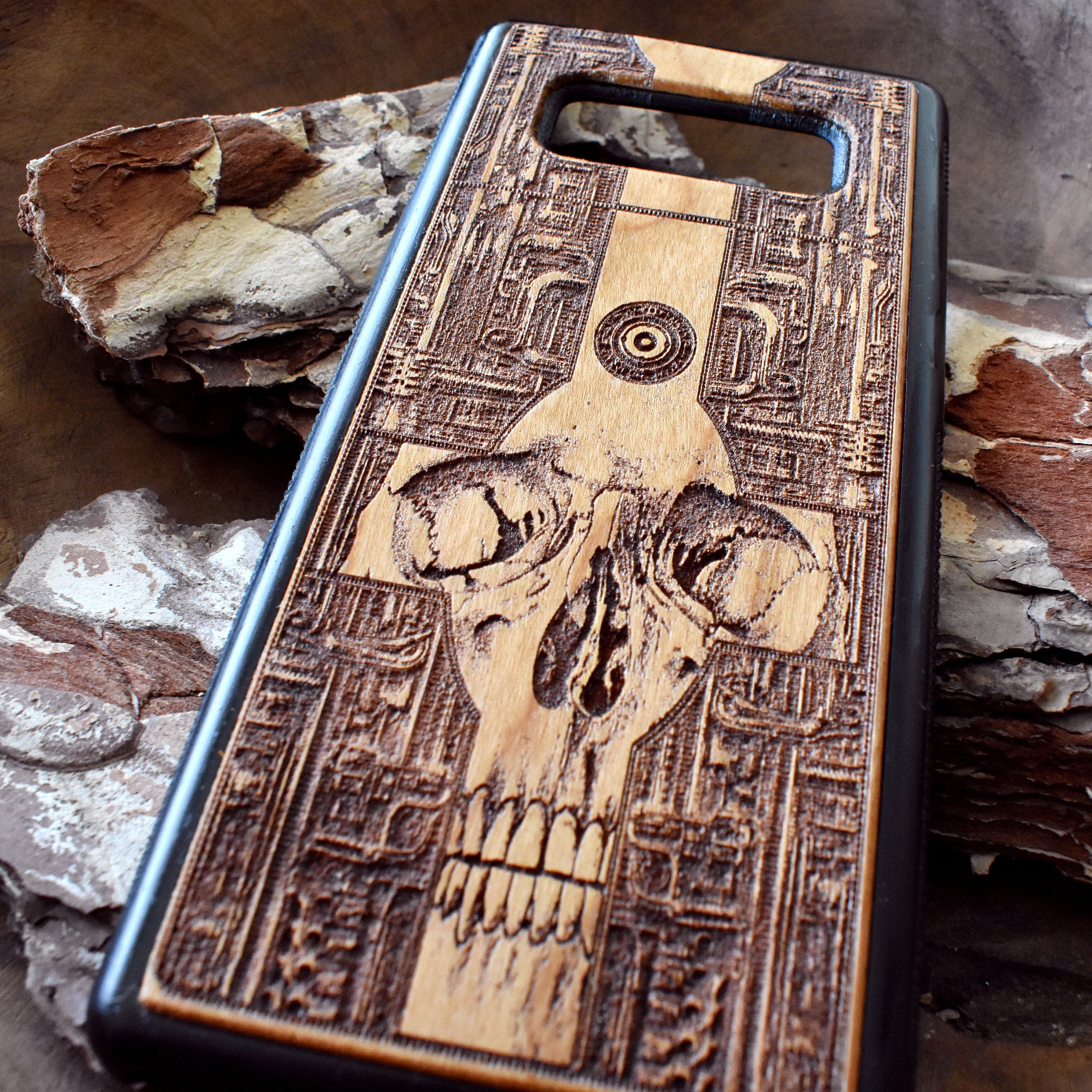Wooden phone case with a detailed gothic skull design, laser-engraved for iPhone , iPhone 15, Galaxy S, Note 20, and more. A unique, durable accessory for fans of dark art.