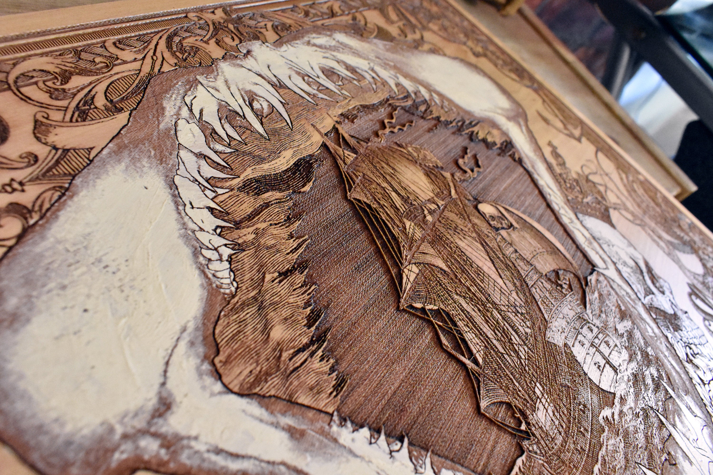 Laser-engraved shark teeth with pirate ship on wood, rustic nautical art.