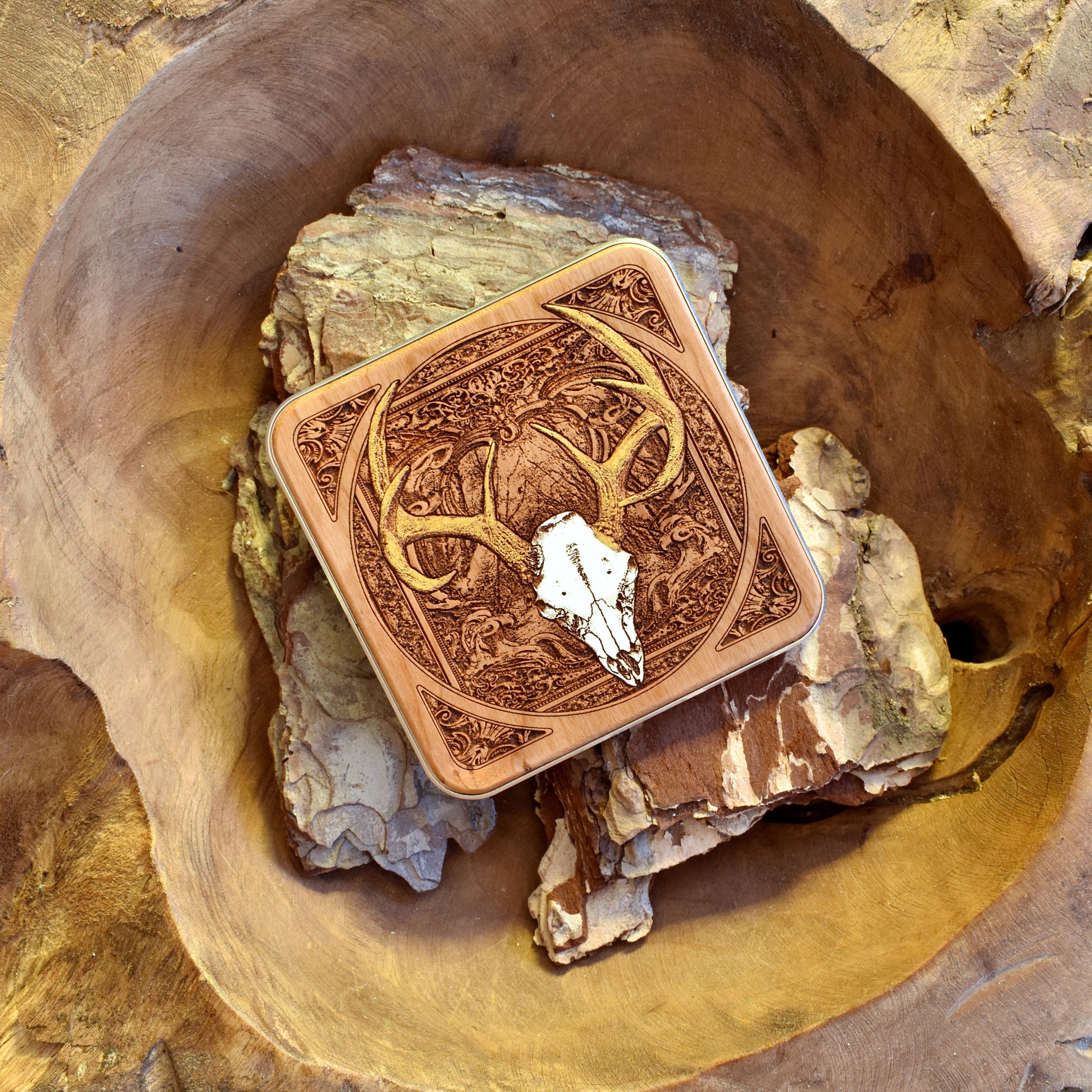 Close-up of deer skull painting on wood wireless charger with gothic design.