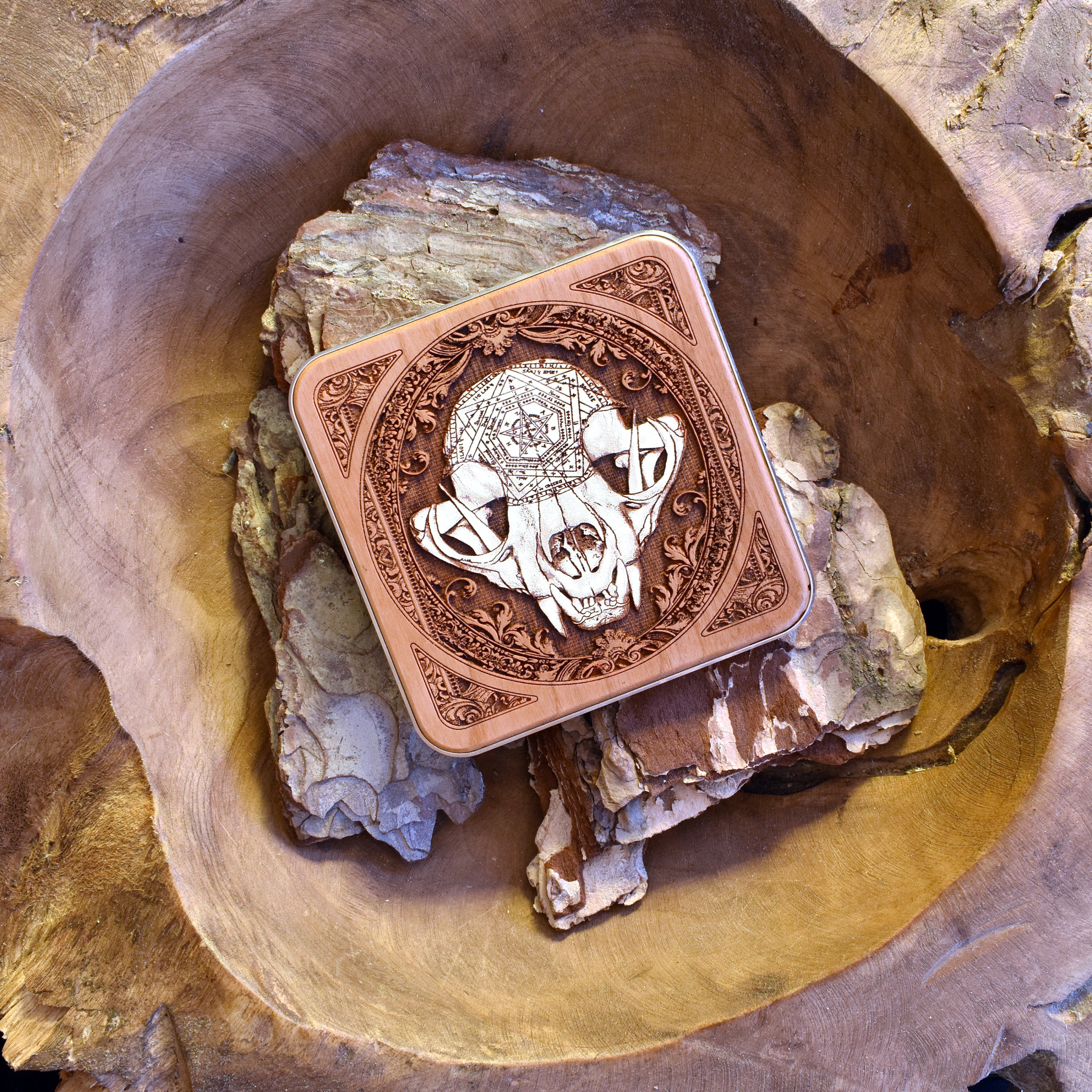 Detailed laser-engraved cat skull design on wooden charging pad, a unique dark art centerpiece.