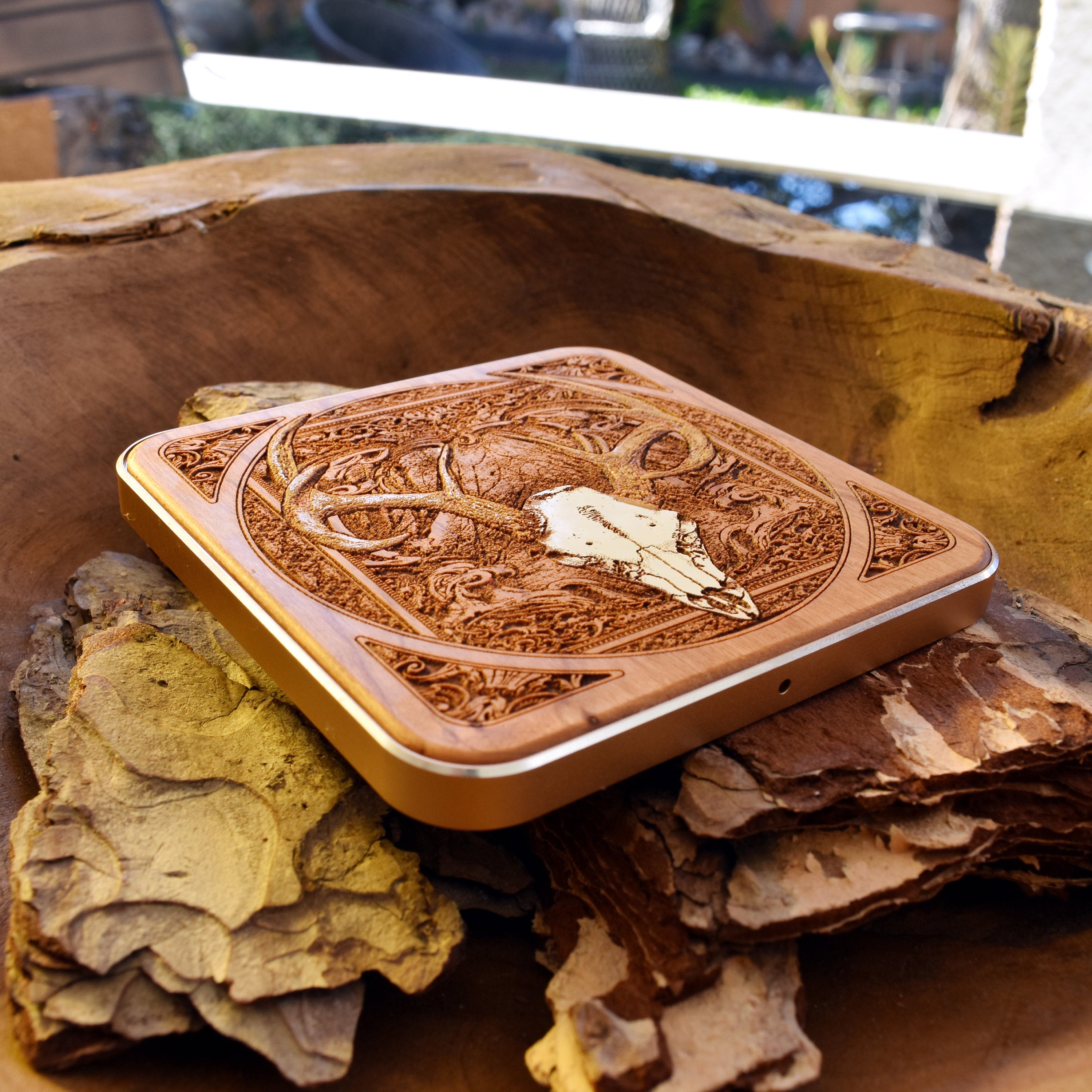Side angle of dark wood wireless charger with hand-painted deer skull.