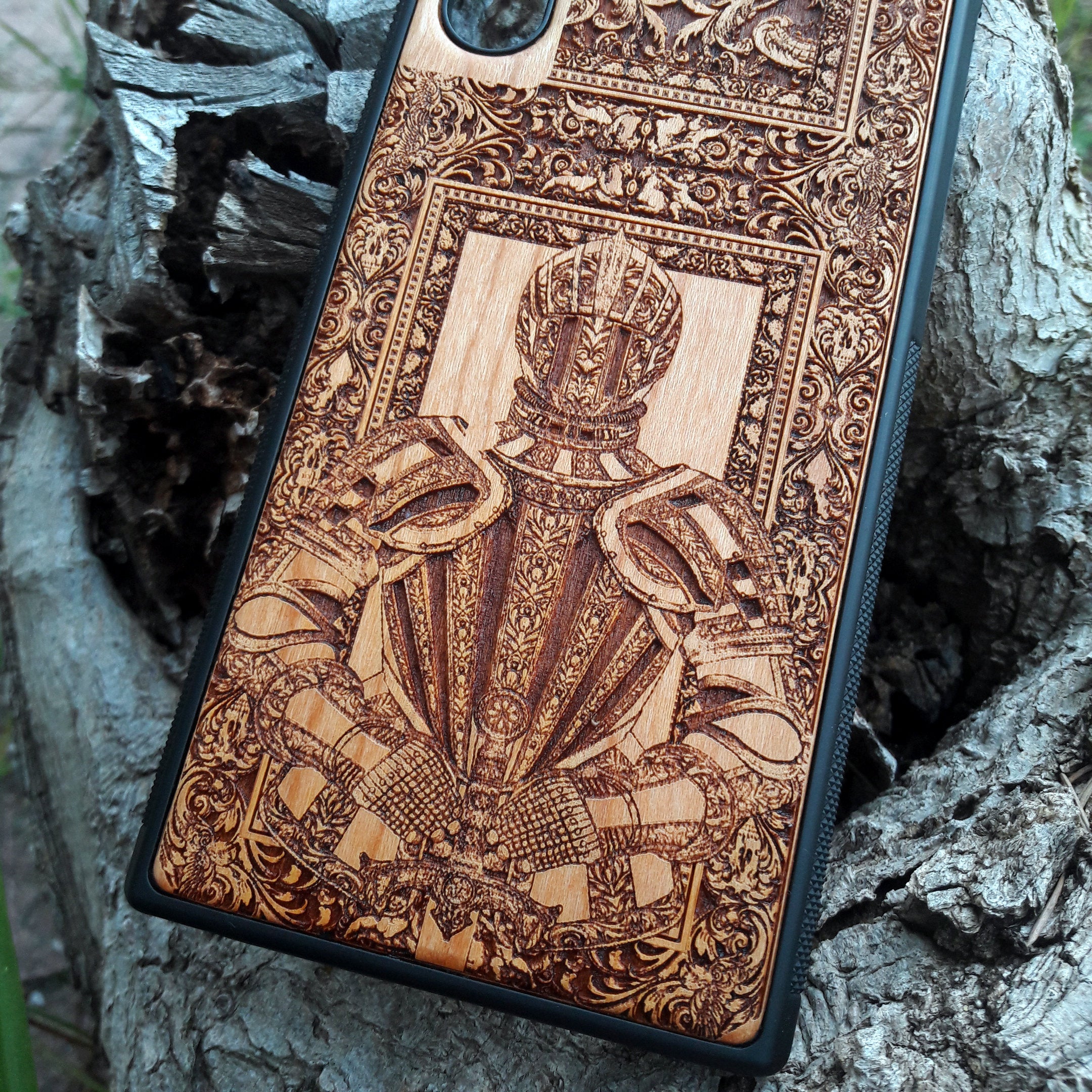Wooden phone case featuring a detailed engraving of a medieval knight's armor, framed by intricate gothic designs. Ideal for iPhone , iPhone 15, iPhone 14, iPhone 13, Samsung Galaxy S, S24, S23, S22, and more. Perfect for lovers of history, knights, and medieval or gothic themes. Provides excellent protection while showcasing a unique, artistic design.