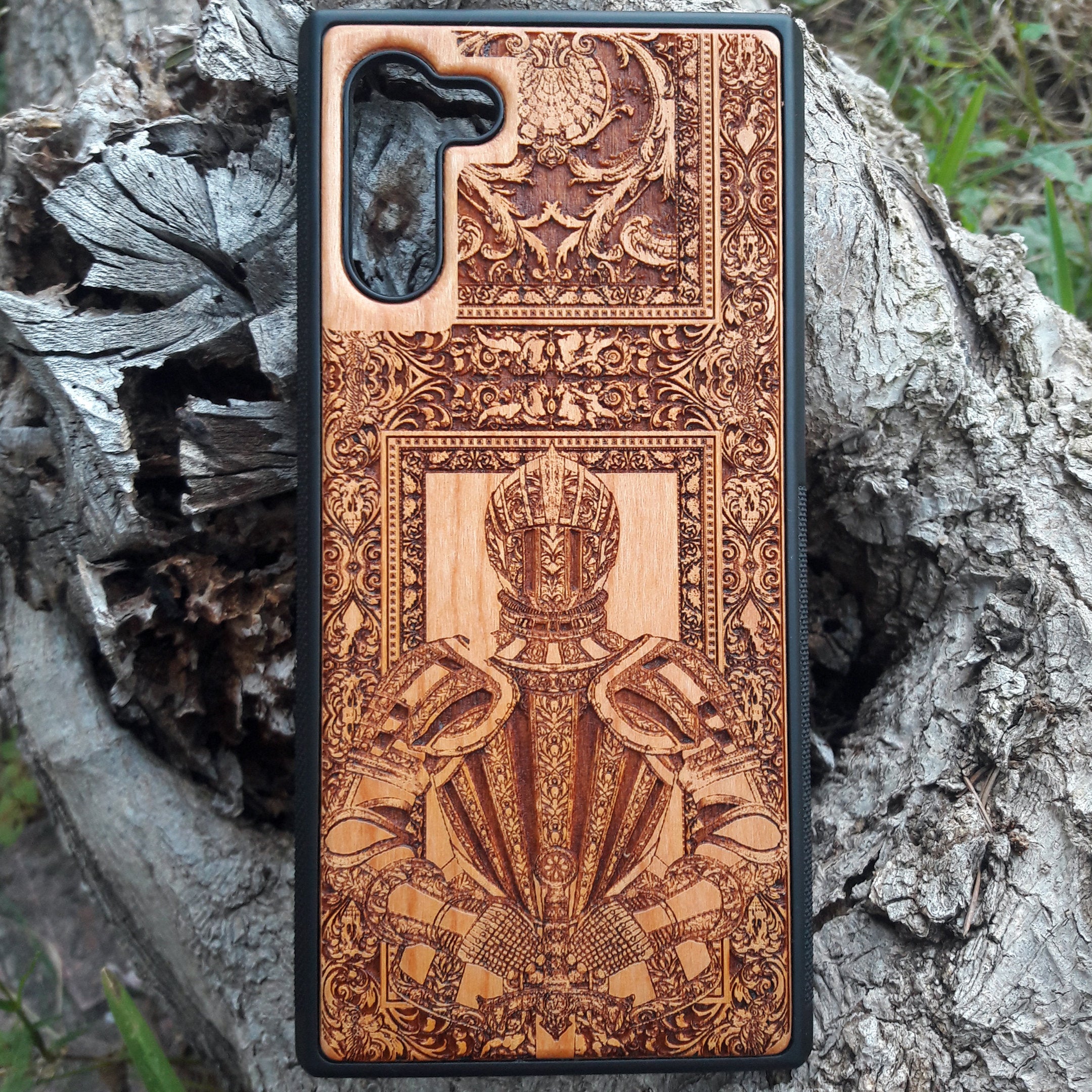 Wooden phone case featuring a detailed engraving of a medieval knight's armor, framed by intricate gothic designs. Ideal for iPhone , iPhone 15, iPhone 14, iPhone 13, Samsung Galaxy S, S24, S23, S22, and more. Perfect for lovers of history, knights, and medieval or gothic themes. Provides excellent protection while showcasing a unique, artistic design.