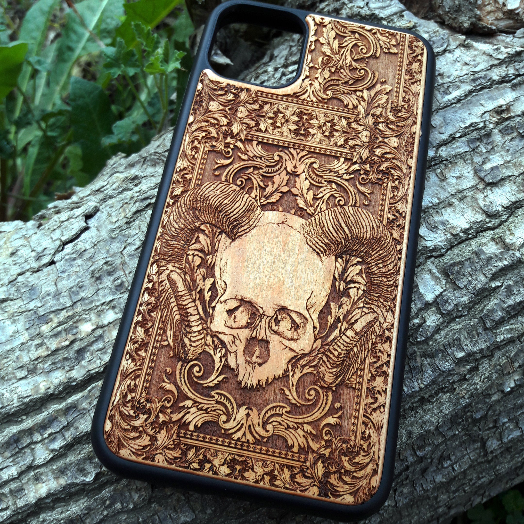 Skull and ram horns laser-engraved wooden phone case for iPhone & Samsung Galaxy – Compatible with iPhone  and Samsung Galaxy S
This optimization focuses on the dark, gothic, and alternative elements of the design, including the skull and ram horns theme, while also highlighting the compatibility with both iPhone and Samsung Galaxy models for better search engine visibility.