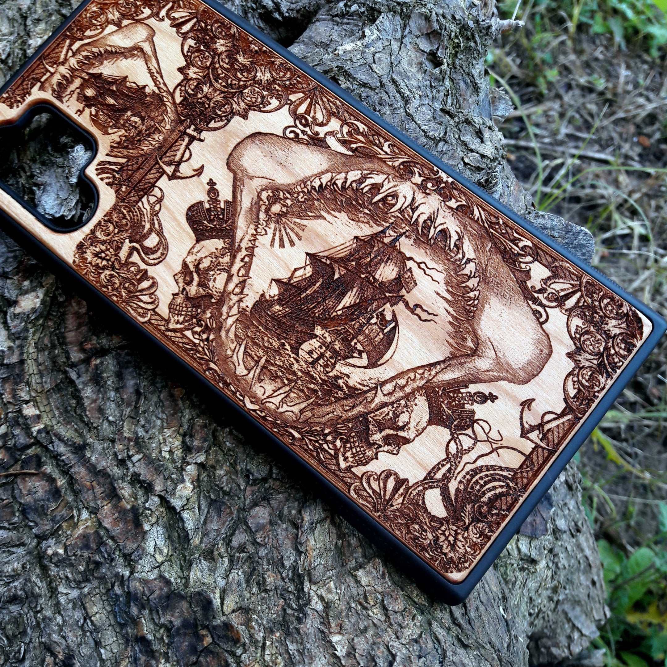 Wooden phone case with an intricate marine shark mandible design, featuring a detailed shipwreck and nautical elements. Laser-engraved on high-quality wood, this case is compatible with iPhone , iPhone 15, Samsung Galaxy S, S24, and more. Perfect for ocean lovers and those seeking a unique, eco-friendly accessory.