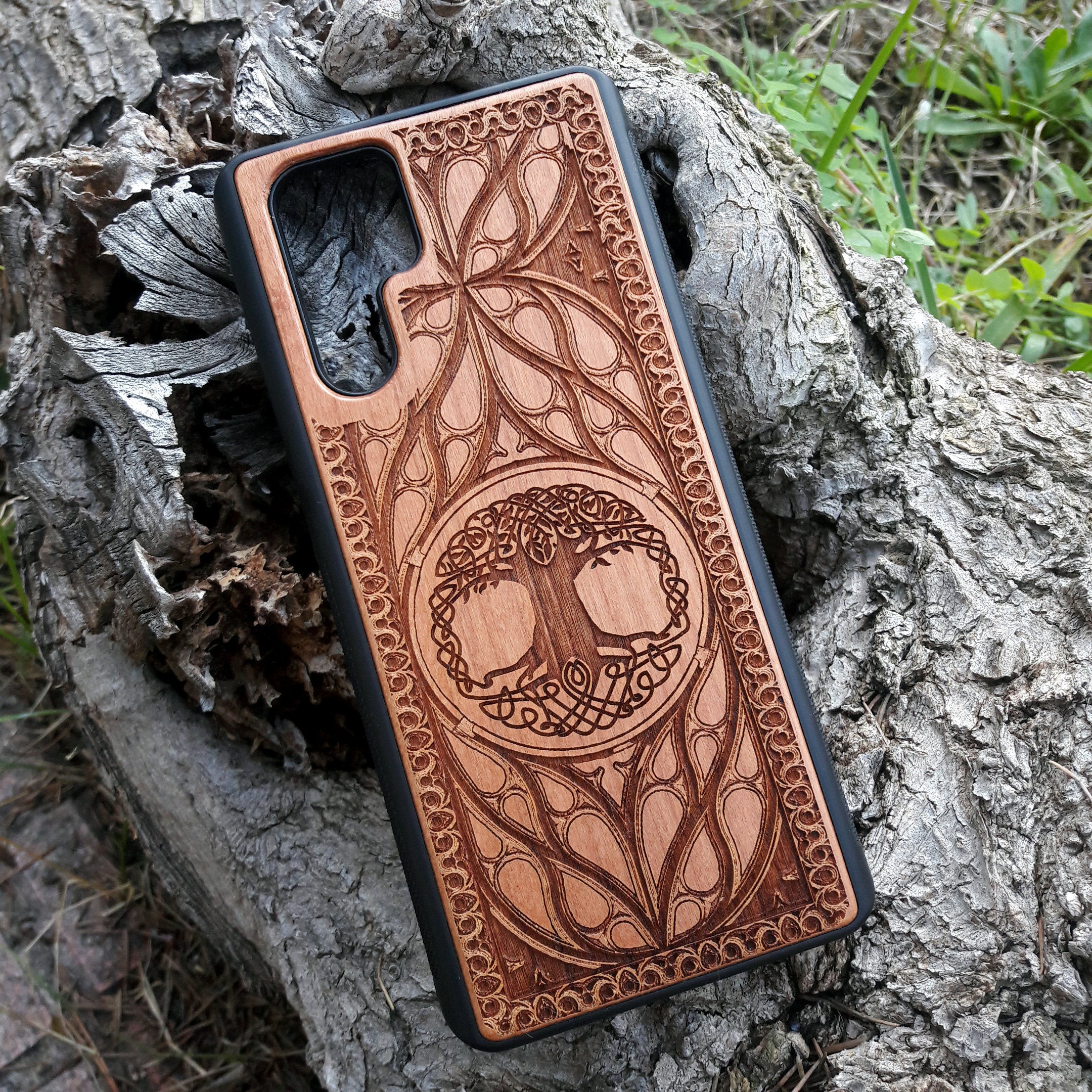 Wood phone case featuring a laser-engraved Tree of Life design surrounded by intricate Celtic-inspired patterns. Durable and stylish, this case is compatible with iPhone , 15, 14, 13, 12, 11, Pro Max, Mini, and Samsung Galaxy S, S24, S23, S22, S21, S20 Ultra, Plus, Note 20. A perfect accessory for nature lovers and fans of Celtic art.