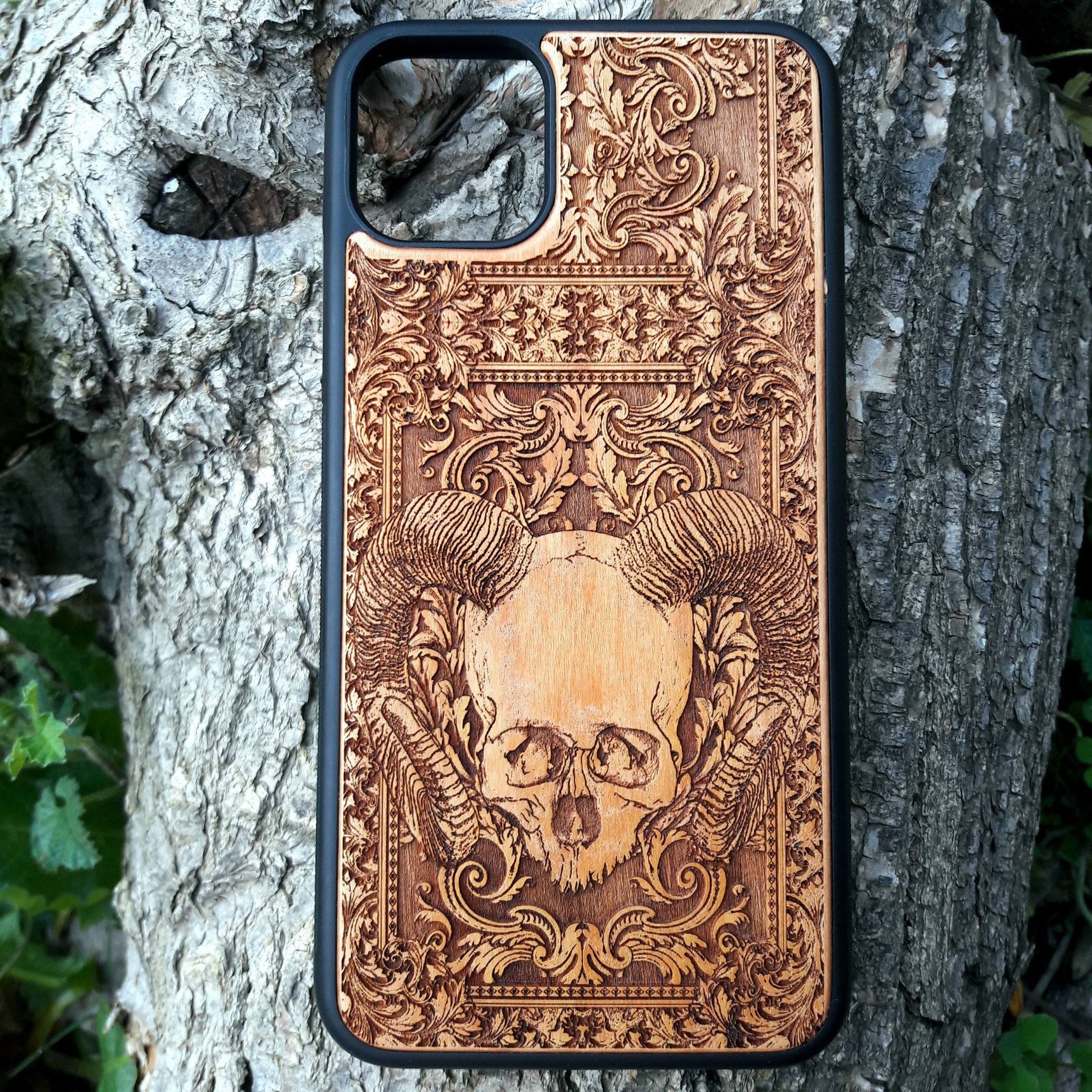 Skull and ram horns laser-engraved wooden phone case for iPhone & Samsung Galaxy – Compatible with iPhone  and Samsung Galaxy S
This optimization focuses on the dark, gothic, and alternative elements of the design, including the skull and ram horns theme, while also highlighting the compatibility with both iPhone and Samsung Galaxy models for better search engine visibility.