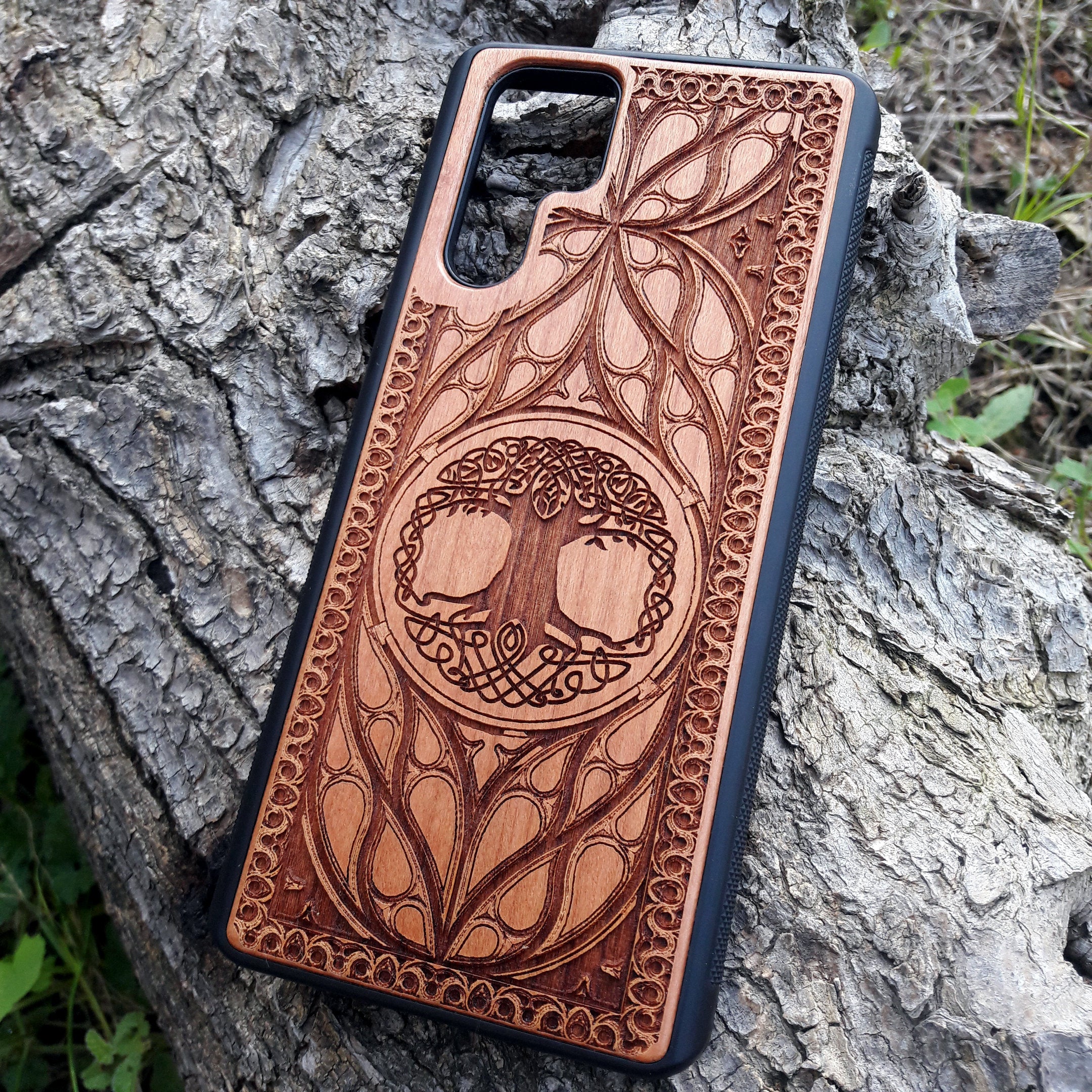 Wood phone case featuring a laser-engraved Tree of Life design surrounded by intricate Celtic-inspired patterns. Durable and stylish, this case is compatible with iPhone , 15, 14, 13, 12, 11, Pro Max, Mini, and Samsung Galaxy S, S24, S23, S22, S21, S20 Ultra, Plus, Note 20. A perfect accessory for nature lovers and fans of Celtic art.