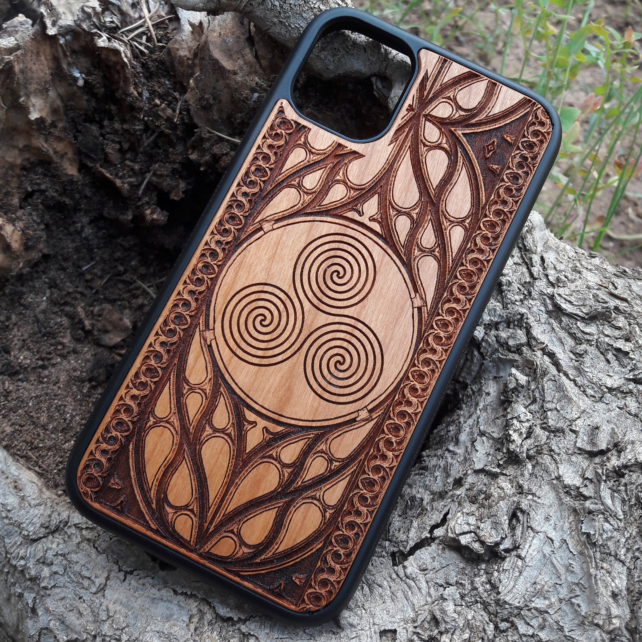 Wooden phone case with a Triskelion Celtic design laser-engraved in a circular pattern, featuring intricate Gothic detailing around the edges. Compatible with iPhone , 15, 14, 13, 12, 11 Pro Max Mini, and Samsung Galaxy S, S24, S23, S22, S21, S20 Ultra Plus, and Note 20. Durable and slim—ideal for lovers of Celtic symbols and unique handcrafted designs.