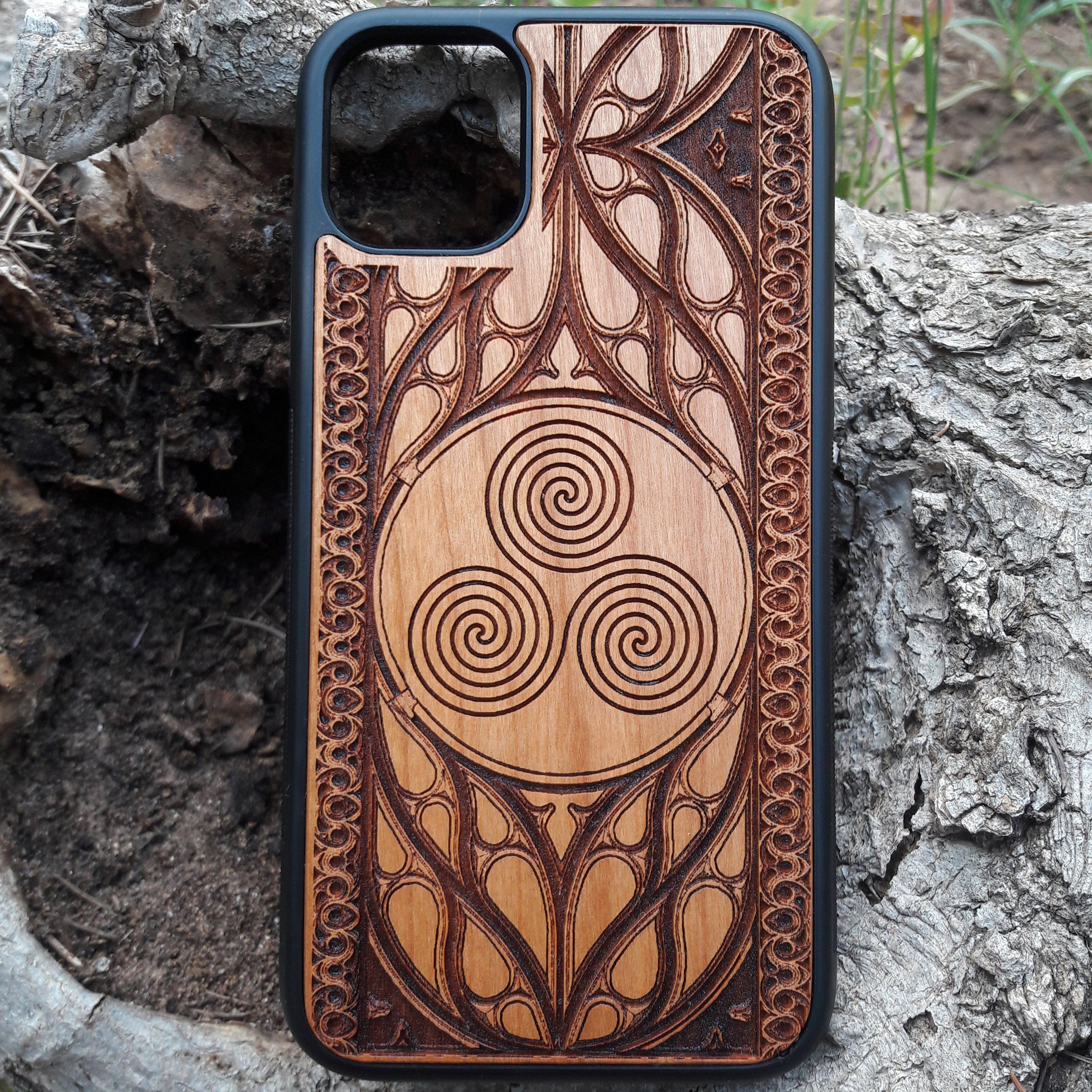 Wooden phone case with a Triskelion Celtic design laser-engraved in a circular pattern, featuring intricate Gothic detailing around the edges. Compatible with iPhone , 15, 14, 13, 12, 11 Pro Max Mini, and Samsung Galaxy S, S24, S23, S22, S21, S20 Ultra Plus, and Note 20. Durable and slim—ideal for lovers of Celtic symbols and unique handcrafted designs.