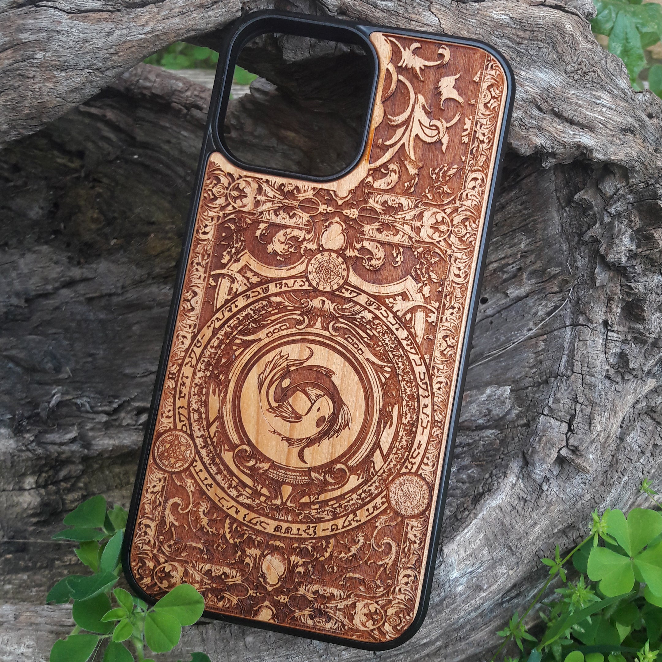 Intricately designed wood phone case featuring a yin-yang koi fish motif surrounded by detailed ornamental patterns and symbolic script. Laser-engraved for precision and durability, this case is compatible with iPhone , 15, 14, 13, 12, 11, Pro Max, Mini, and Samsung Galaxy S, S24, S23, S22, S21, S20 Ultra, Plus, Note 20. A unique and artistic accessory for those seeking elegance and protection.