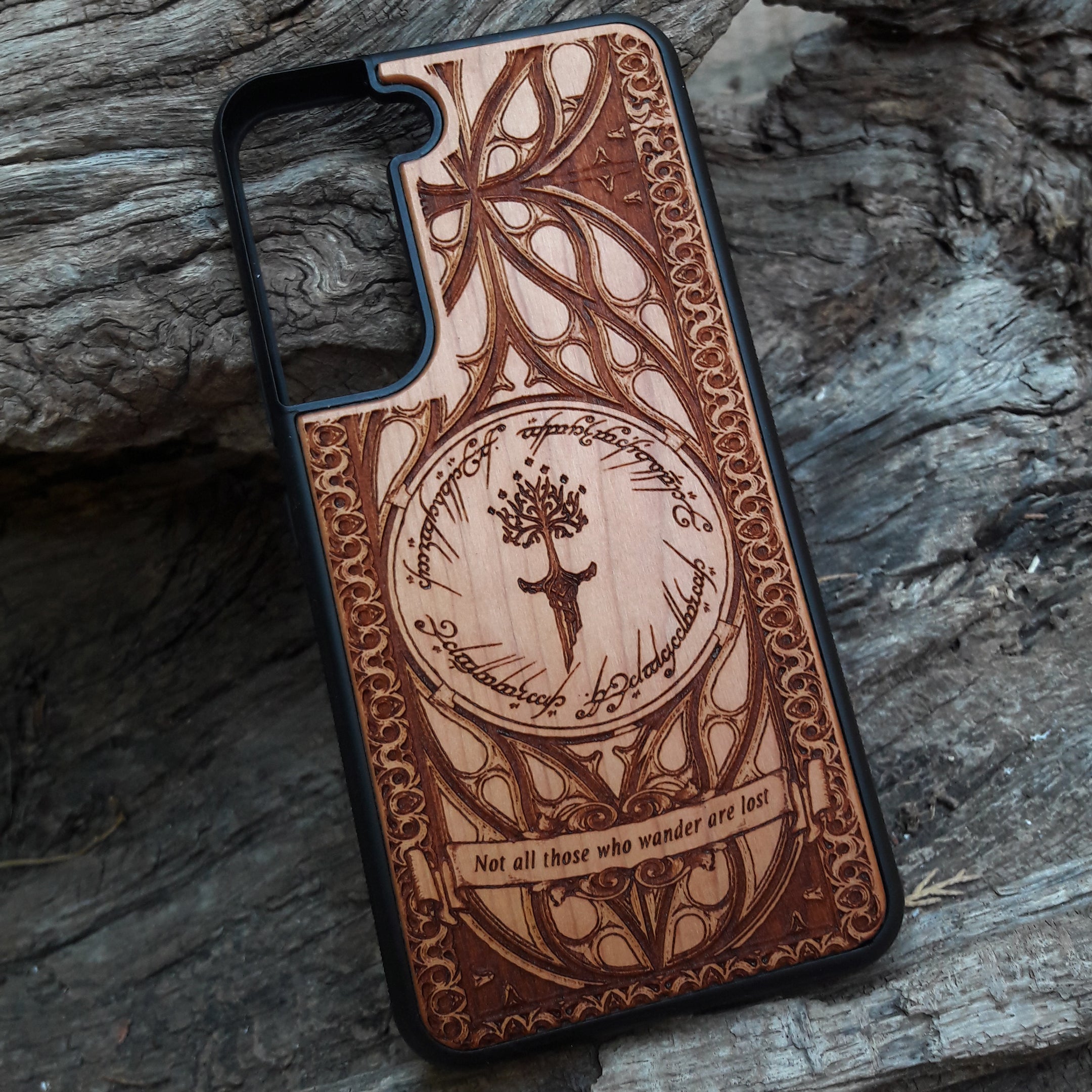 Lord of the Rings wood phone case featuring the White Tree of Gondor, Elvish script, and the iconic quote 'Not all those who wander are lost.' Laser-engraved for intricate detailing and crafted for durability, this case is compatible with iPhone , 15, 14, 13, 12, 11, Pro Max, Mini, and Samsung Galaxy S, S24, S23, S22, S21, S20 Ultra, Plus, Note 20. A perfect protective accessory for Tolkien fans.