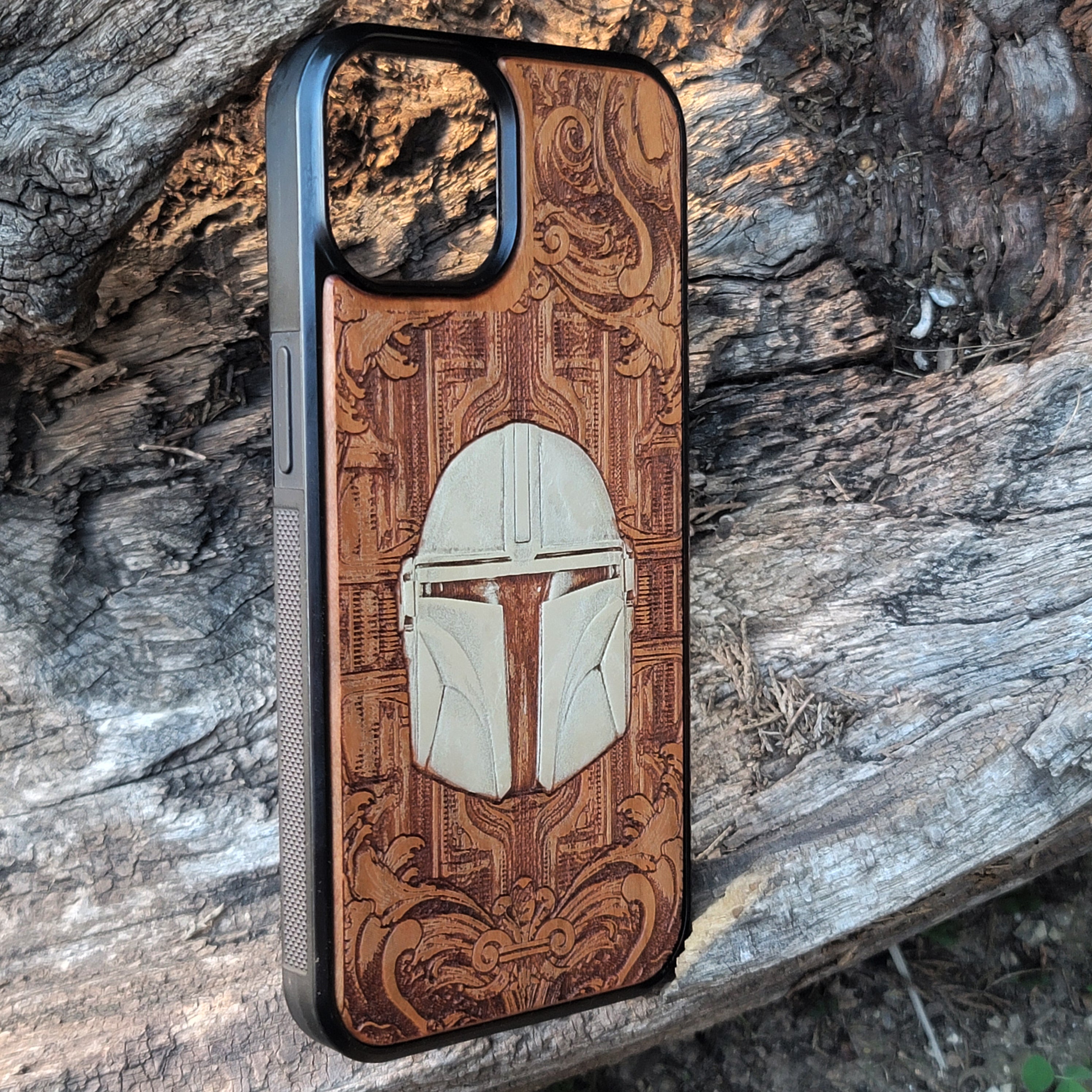 Cherrywood phone case featuring a laser-engraved Mandalorian helmet, a unique Star Wars gift for iPhone & Galaxy users.
