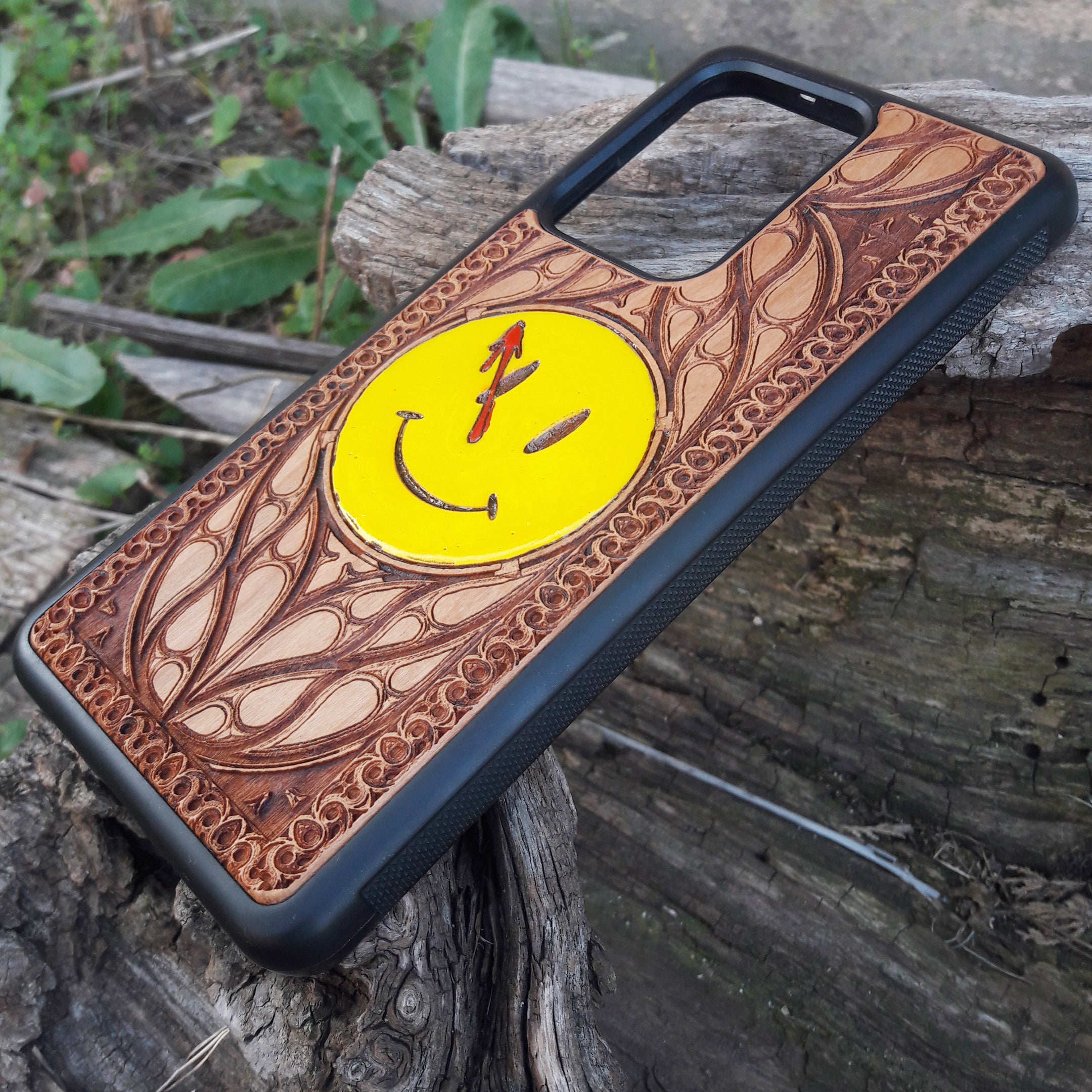 Wooden phone case for iPhone and Samsung Galaxy featuring the 'Smiley' symbol from the Watchmen saga, laser-engraved for a unique touch. Compatible with iPhone 15, 14, 13, 12, 11 Pro Max Mini and Samsung Galaxy S24, S23, S22, S21, S20 Ultra Plus Note 20. Slim, durable, and stylish—order now to make a statement!