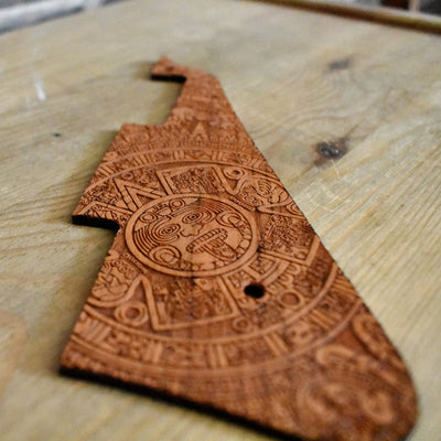 Handcrafted wooden guitar pickguard featuring Aztec calendar symbols.