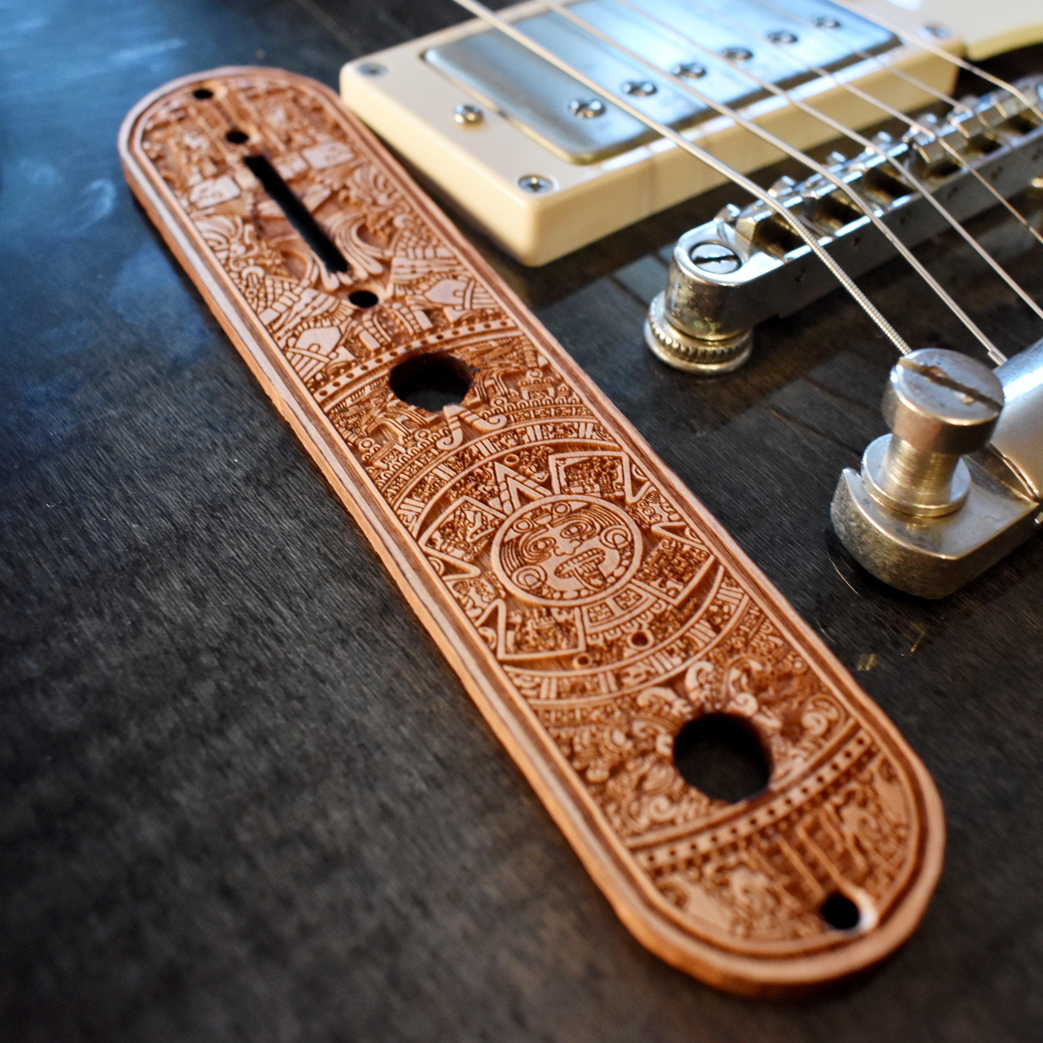 Laser‑engraved wood control plate replacement for Telecaster guitar featuring Aztec calendar motif