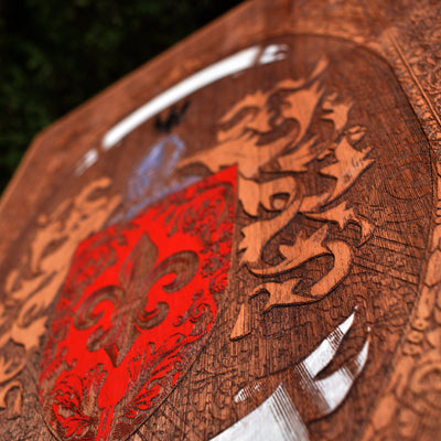 Dark wood coat of arms artwork with gothic-style engraved heraldic design.