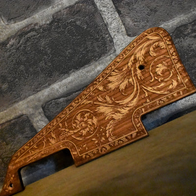 Close-up of laser-engraved cherry wood pickguard for Gibson Les Paul