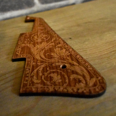 Close-up of wooden pickguard featuring a delicate flourish pattern, designed to fit Gibson Les Paul '59 and Standard models