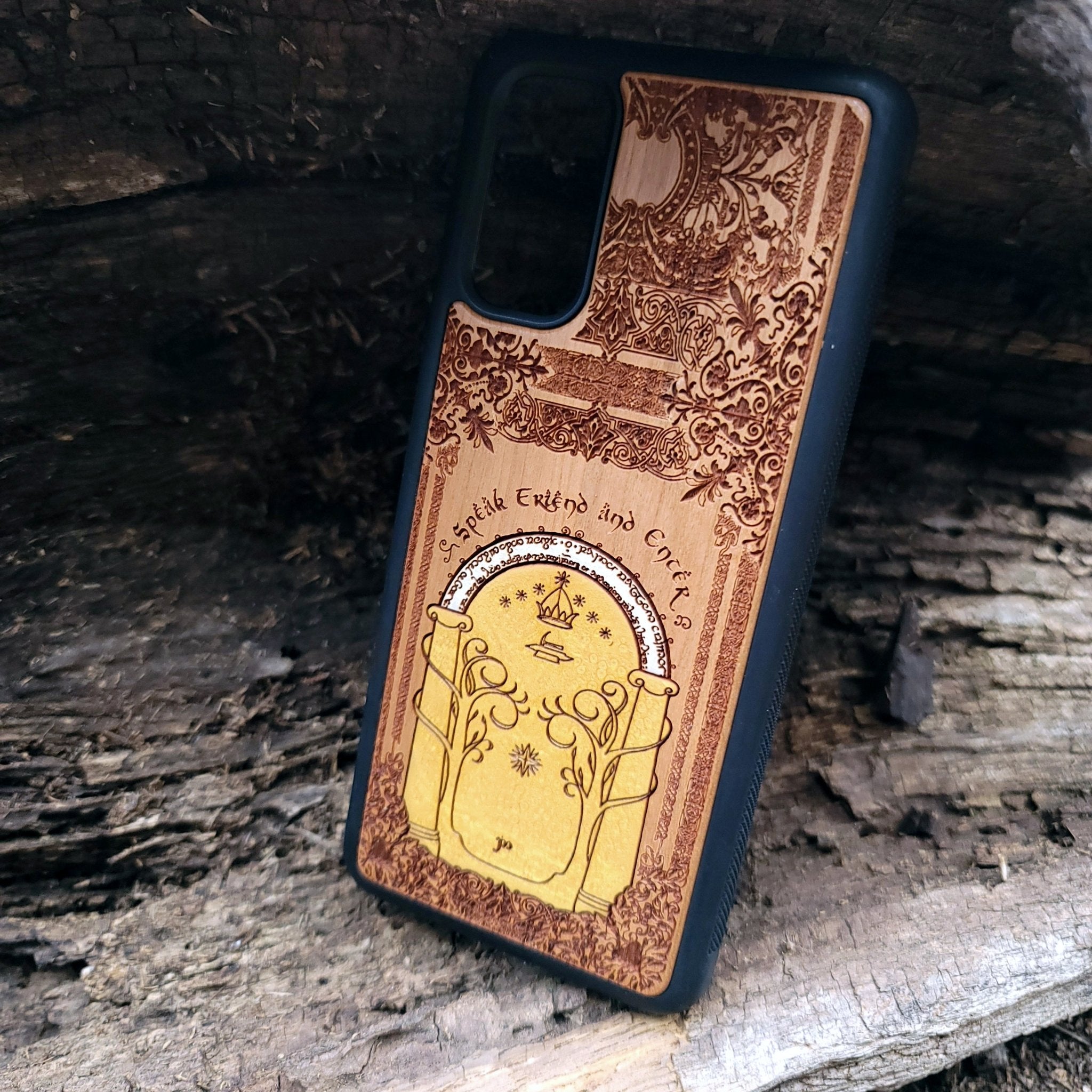 Wooden phone case featuring a gothic Lord of the Rings-inspired design of the Gate of Moria. The intricate laser-engraving showcases the iconic dwarven door from the Mines of Moria, adorned with Elvish script and decorative elements. Compatible with iPhone , 15, 14, 13, 12, 11 Pro Max Mini and Samsung Galaxy S, S24, S23, S22, S21, S20 Ultra, Plus, Note 20. A unique and durable accessory perfect for fans of Tolkien’s Middle-earth.