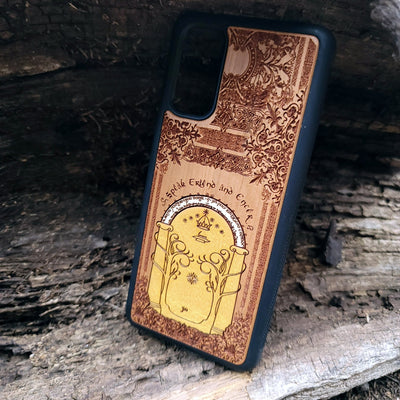 Wooden phone case featuring a gothic Lord of the Rings-inspired design of the Gate of Moria. The intricate laser-engraving showcases the iconic dwarven door from the Mines of Moria, adorned with Elvish script and decorative elements. Compatible with iPhone , 15, 14, 13, 12, 11 Pro Max Mini and Samsung Galaxy S, S24, S23, S22, S21, S20 Ultra, Plus, Note 20. A unique and durable accessory perfect for fans of Tolkien’s Middle-earth.