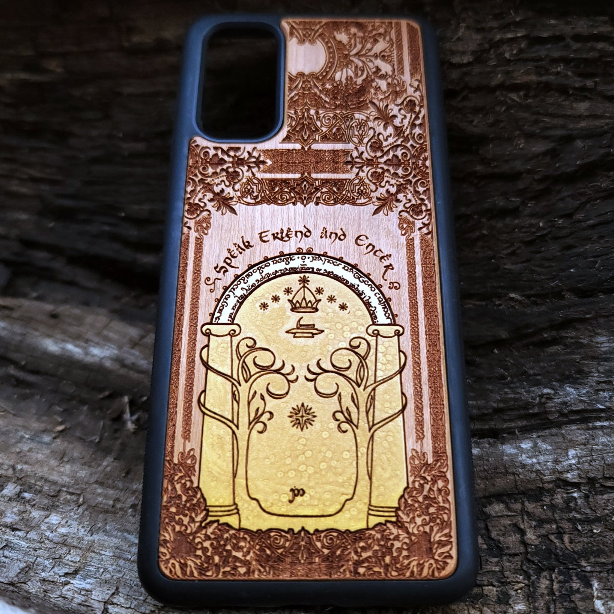 Wooden phone case featuring a gothic Lord of the Rings-inspired design of the Gate of Moria. The intricate laser-engraving showcases the iconic dwarven door from the Mines of Moria, adorned with Elvish script and decorative elements. Compatible with iPhone , 15, 14, 13, 12, 11 Pro Max Mini and Samsung Galaxy S, S24, S23, S22, S21, S20 Ultra, Plus, Note 20. A unique and durable accessory perfect for fans of Tolkien’s Middle-earth.
