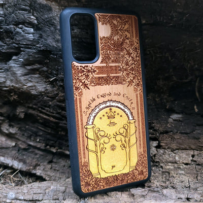 Wooden phone case featuring a gothic Lord of the Rings-inspired design of the Gate of Moria. The intricate laser-engraving showcases the iconic dwarven door from the Mines of Moria, adorned with Elvish script and decorative elements. Compatible with iPhone , 15, 14, 13, 12, 11 Pro Max Mini and Samsung Galaxy S, S24, S23, S22, S21, S20 Ultra, Plus, Note 20. A unique and durable accessory perfect for fans of Tolkien’s Middle-earth.