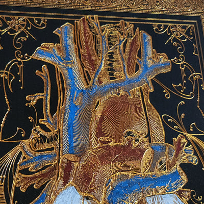 Wood heart wall art with black stain and golden engraved vascular details.