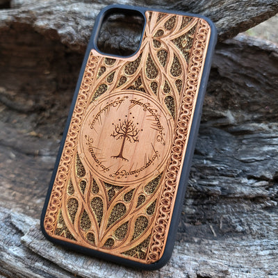 Lord of the Rings wood phone case featuring the White Tree of Gondor surrounded by Elvish script and intricate, detailed patterns. Laser-engraved with precision and a natural wood finish, this durable case is compatible with iPhone , 15, 14, 13, 12, 11, Pro Max, Mini, and Samsung Galaxy S, S24, S23, S22, S21, S20 Ultra, Plus, Note 20. A stylish and protective accessory for Tolkien fans.
