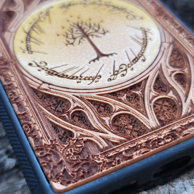 Close-up of cherry wood phone case featuring intricate Lord of the Rings design for iPhone & Galaxy