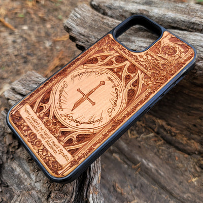 Lord of the Rings wood phone case featuring the Sword of Andúril, Elvish script, and a detailed ornate design. Laser-engraved with the quote 'Nanye Andúril i ne Narsil i macil Elendilo. Lercuvanten i mali Mordoreo.' This durable and artistic case is compatible with iPhone , 15, 14, 13, 12, 11, Pro Max, Mini, and Samsung Galaxy S, S24, S23, S22, S21, S20 Ultra, Plus, Note 20. A perfect protective accessory for Tolkien fans.