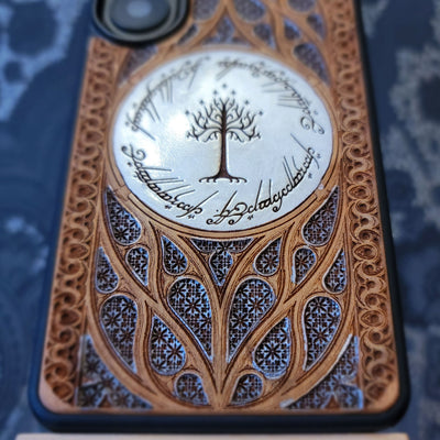 Phone case with intricate design and tree of Gondor emblem on a grey background