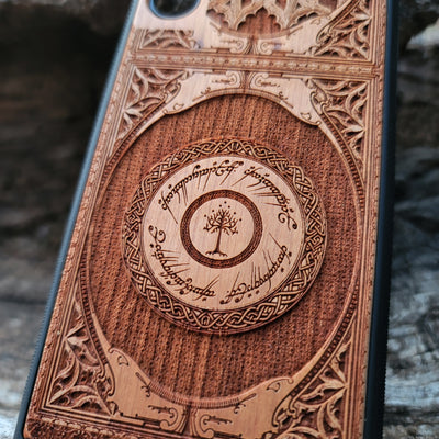 Wooden phone case featuring a gothic Lord of the Rings-inspired design with intricate engravings of the iconic White Tree of Gondor and Elvish script. The laser-engraved details capture the elegance and mystique of Tolkien’s world, perfect for fans of Middle-earth. Compatible with iPhone , 15, 14, 13, 12, 11 Pro Max Mini, and Samsung Galaxy S, S24, S23, S22, S21, S20 Ultra, Plus, Note 20. A unique, durable, and stylish accessory for LOTR enthusiasts.