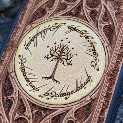Close-up of cherry wood phone case featuring intricate Lord of the Rings design for iPhone & Galaxy