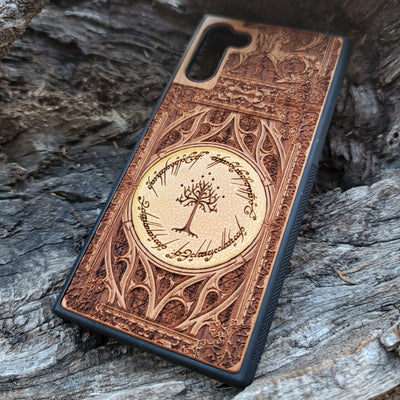 Close-up of cherry wood phone case featuring intricate Lord of the Rings design for iPhone & Galaxy