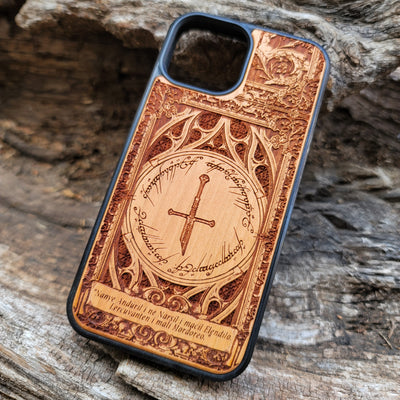 Lord of the Rings wood phone case featuring the Sword of Andúril, Elvish script, and a detailed ornate design. Laser-engraved with the quote 'Nanye Andúril i ne Narsil i macil Elendilo. Lercuvanten i mali Mordoreo.' This durable and artistic case is compatible with iPhone , 15, 14, 13, 12, 11, Pro Max, Mini, and Samsung Galaxy S, S24, S23, S22, S21, S20 Ultra, Plus, Note 20. A perfect protective accessory for Tolkien fans.
