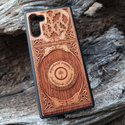 Wooden phone case featuring a gothic Lord of the Rings-inspired design with intricate engravings of the iconic White Tree of Gondor and Elvish script. The laser-engraved details capture the elegance and mystique of Tolkien’s world, perfect for fans of Middle-earth. Compatible with iPhone , 15, 14, 13, 12, 11 Pro Max Mini, and Samsung Galaxy S, S24, S23, S22, S21, S20 Ultra, Plus, Note 20. A unique, durable, and stylish accessory for LOTR enthusiasts.