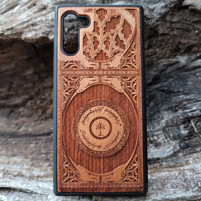 Wooden phone case featuring a gothic Lord of the Rings-inspired design with intricate engravings of the iconic White Tree of Gondor and Elvish script. The laser-engraved details capture the elegance and mystique of Tolkien’s world, perfect for fans of Middle-earth. Compatible with iPhone , 15, 14, 13, 12, 11 Pro Max Mini, and Samsung Galaxy S, S24, S23, S22, S21, S20 Ultra, Plus, Note 20. A unique, durable, and stylish accessory for LOTR enthusiasts.